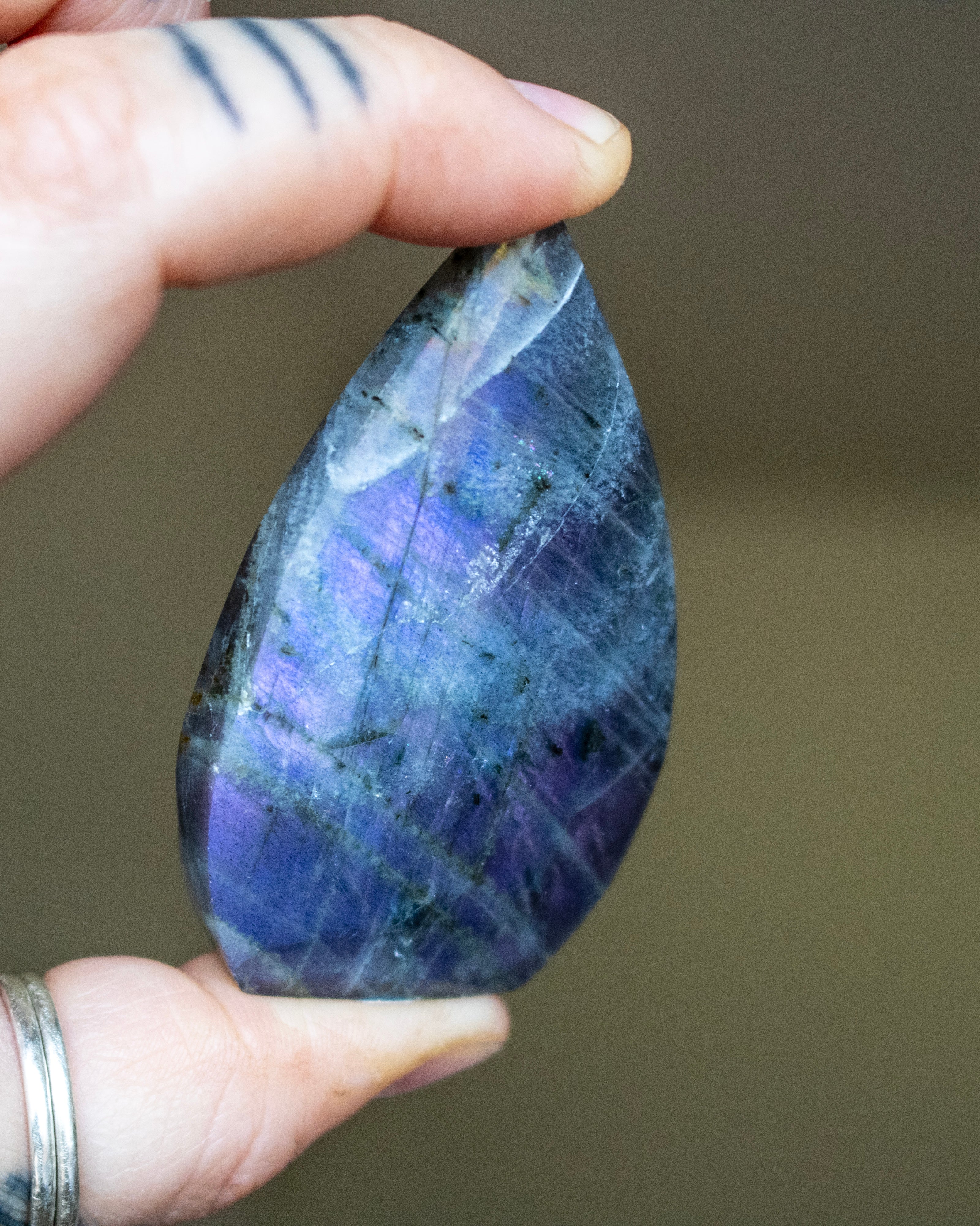 Teardrop-shaped crystal with multicolored patterns on a neutral background