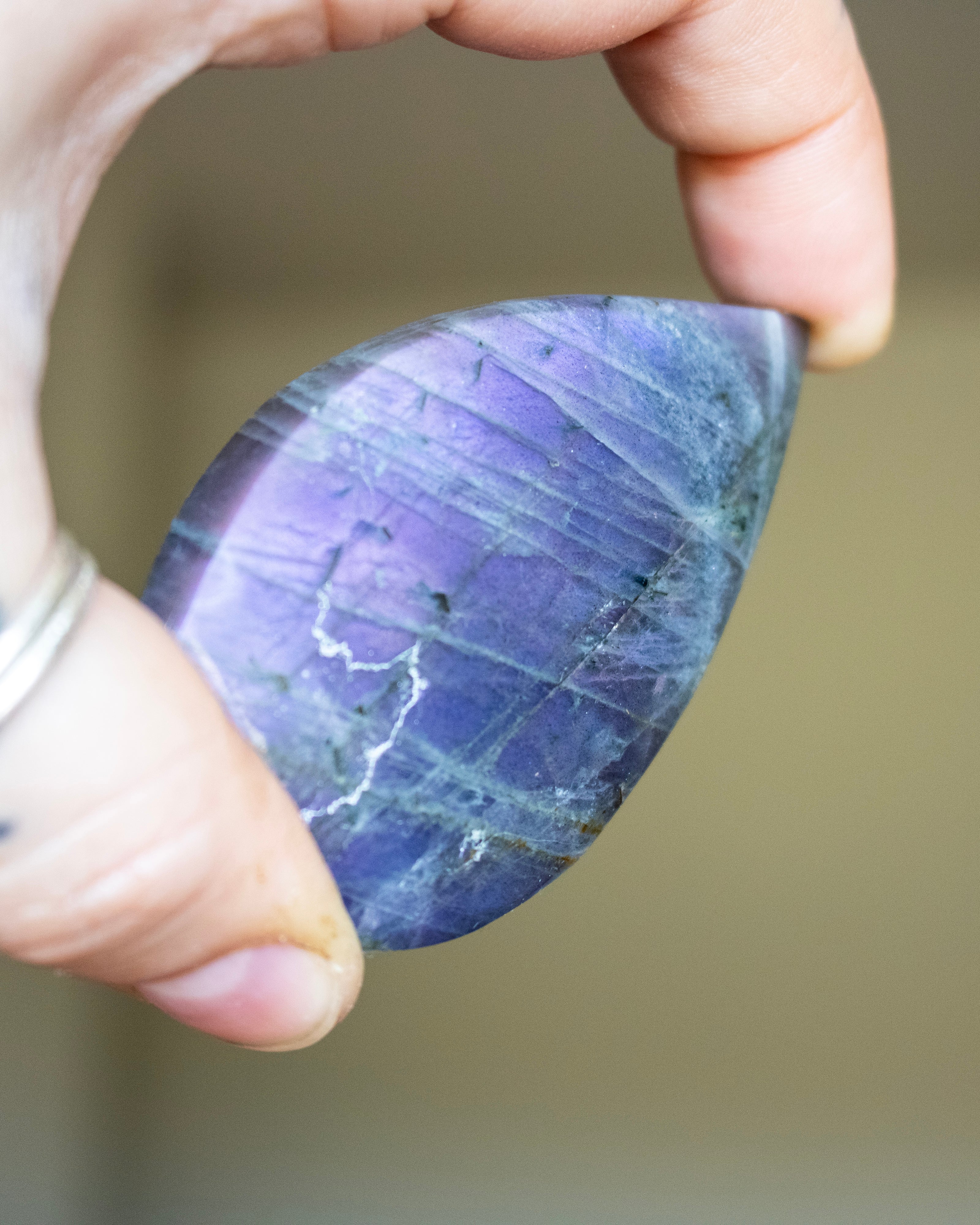 Hand holding a purple stone with a blurred background