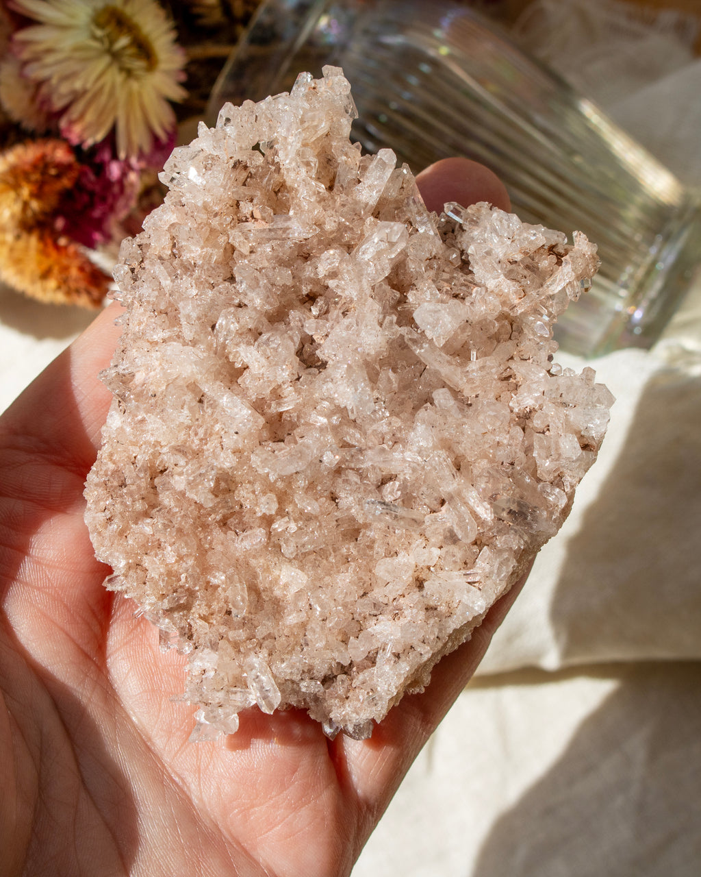 Hand holding a large crystal rock with a blurred background