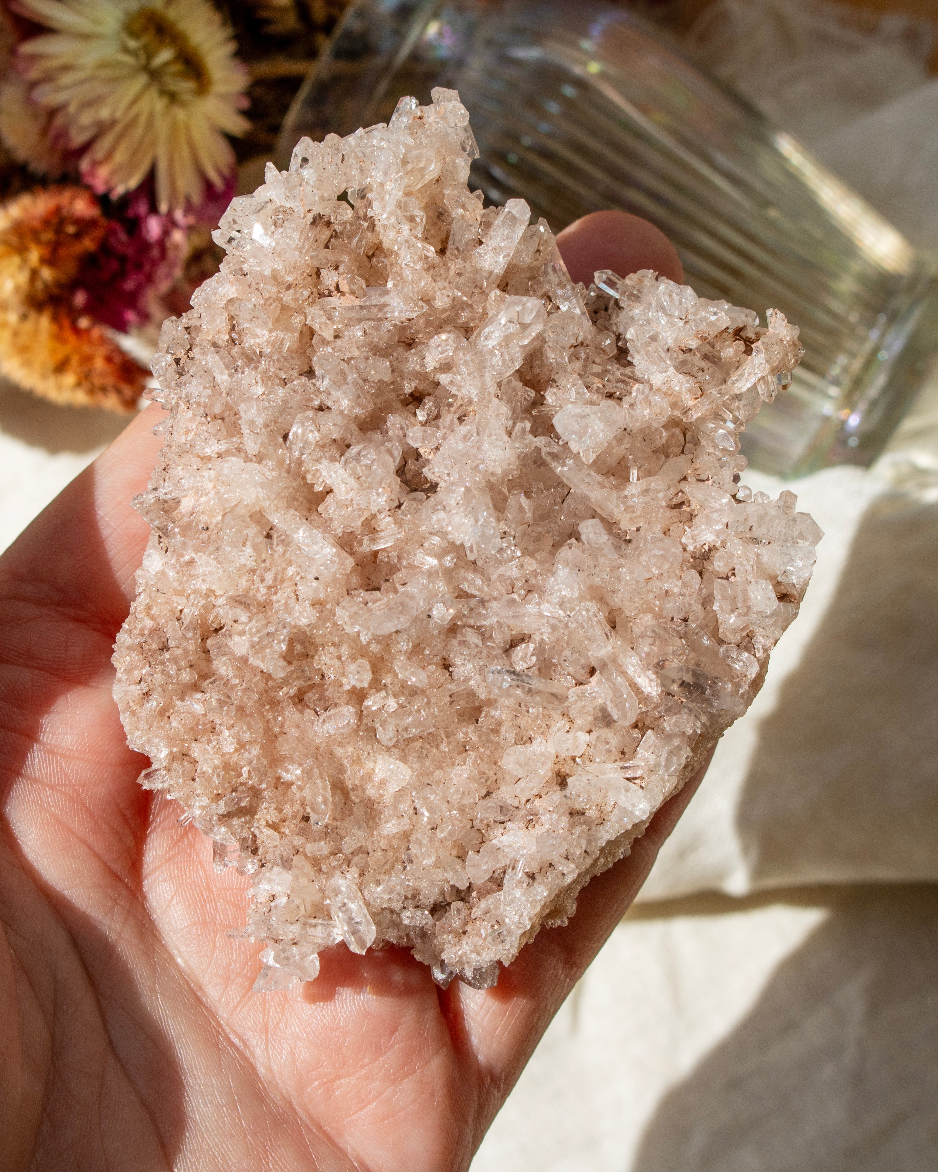 Hand holding a large crystal rock with a blurred background
