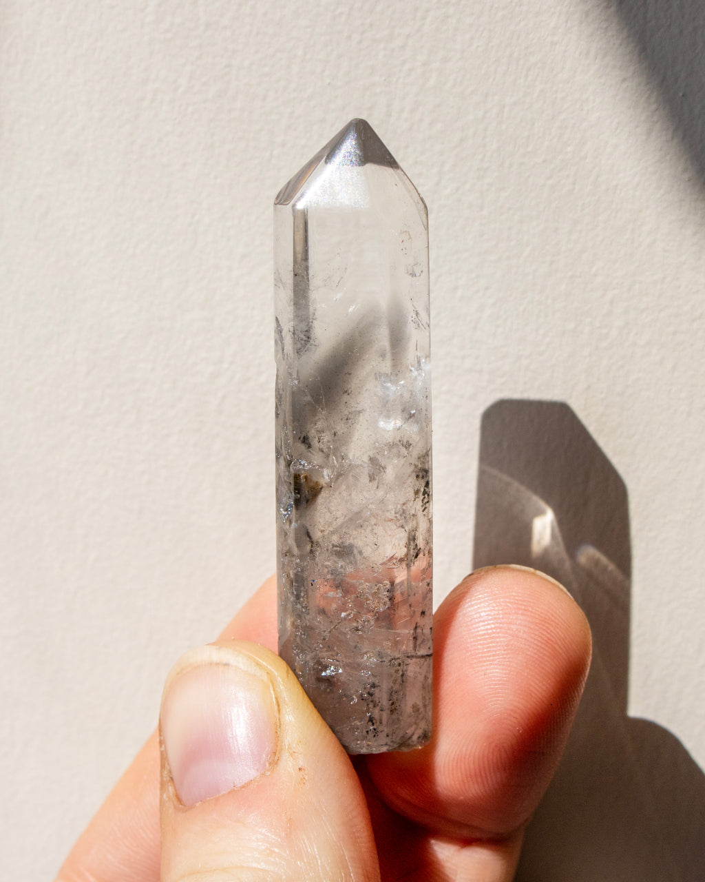 a clear crystal being held against a neutral background