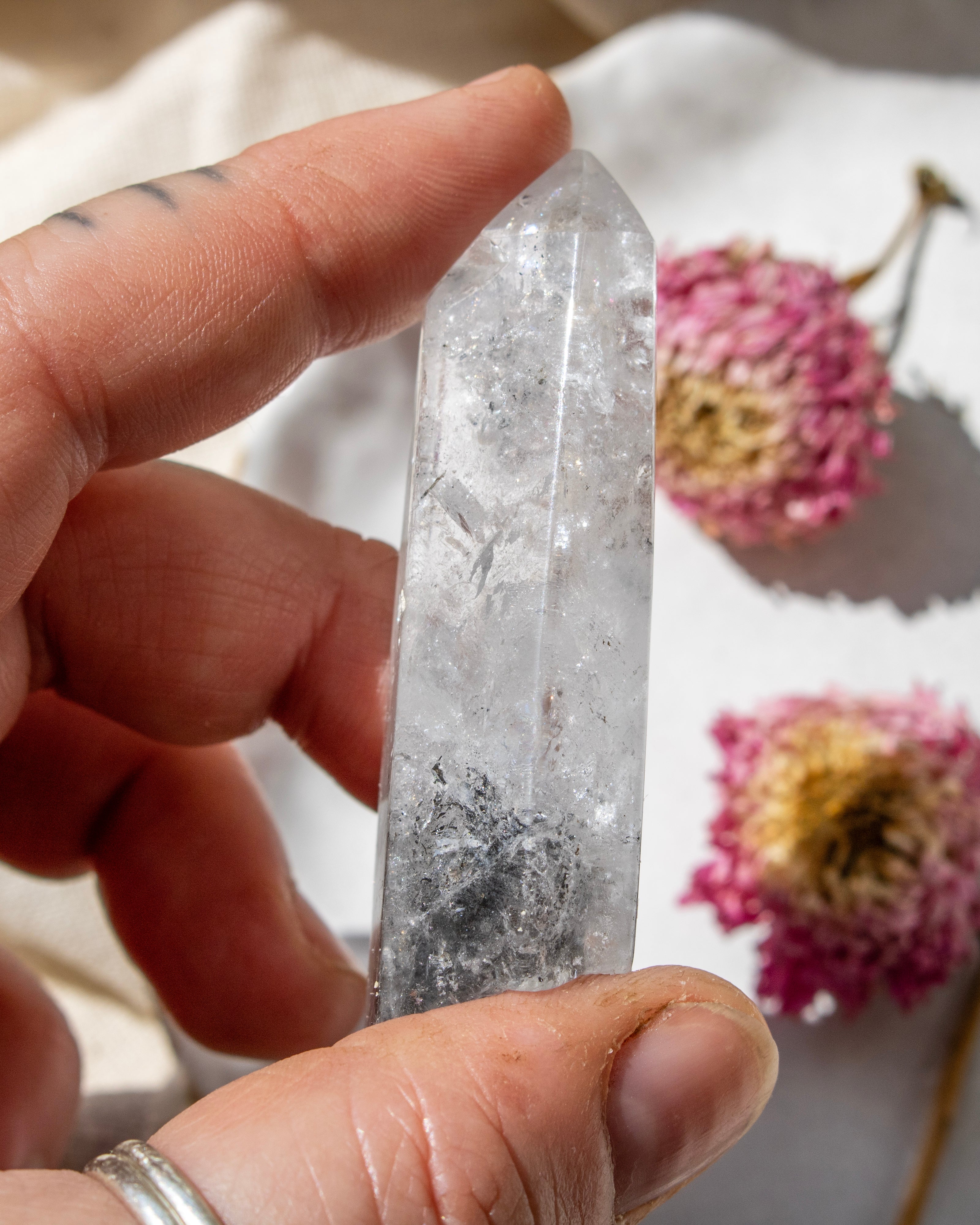 a clear crystal on being held with dried flowers