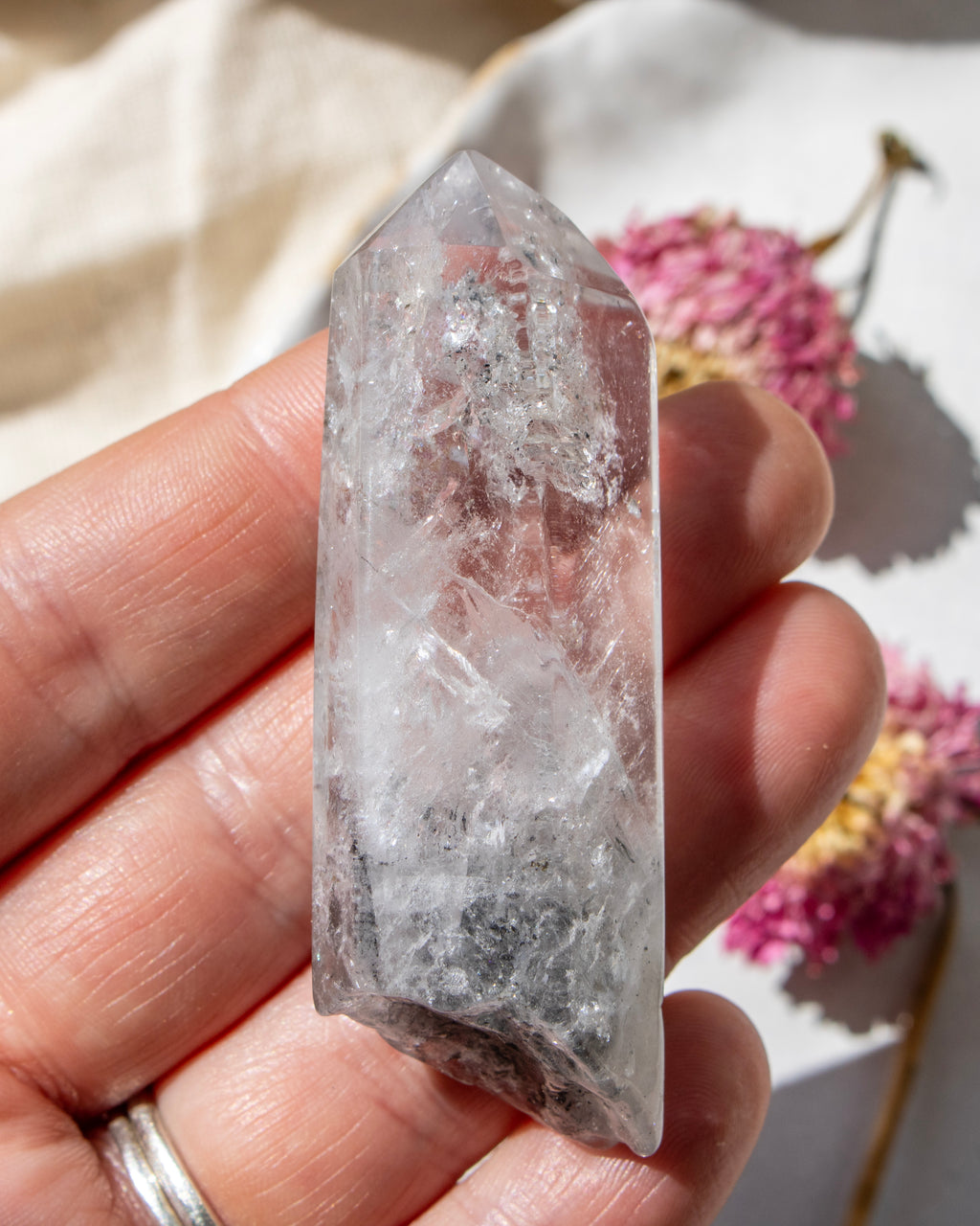 Clear crystal held in a hand with a soft background
