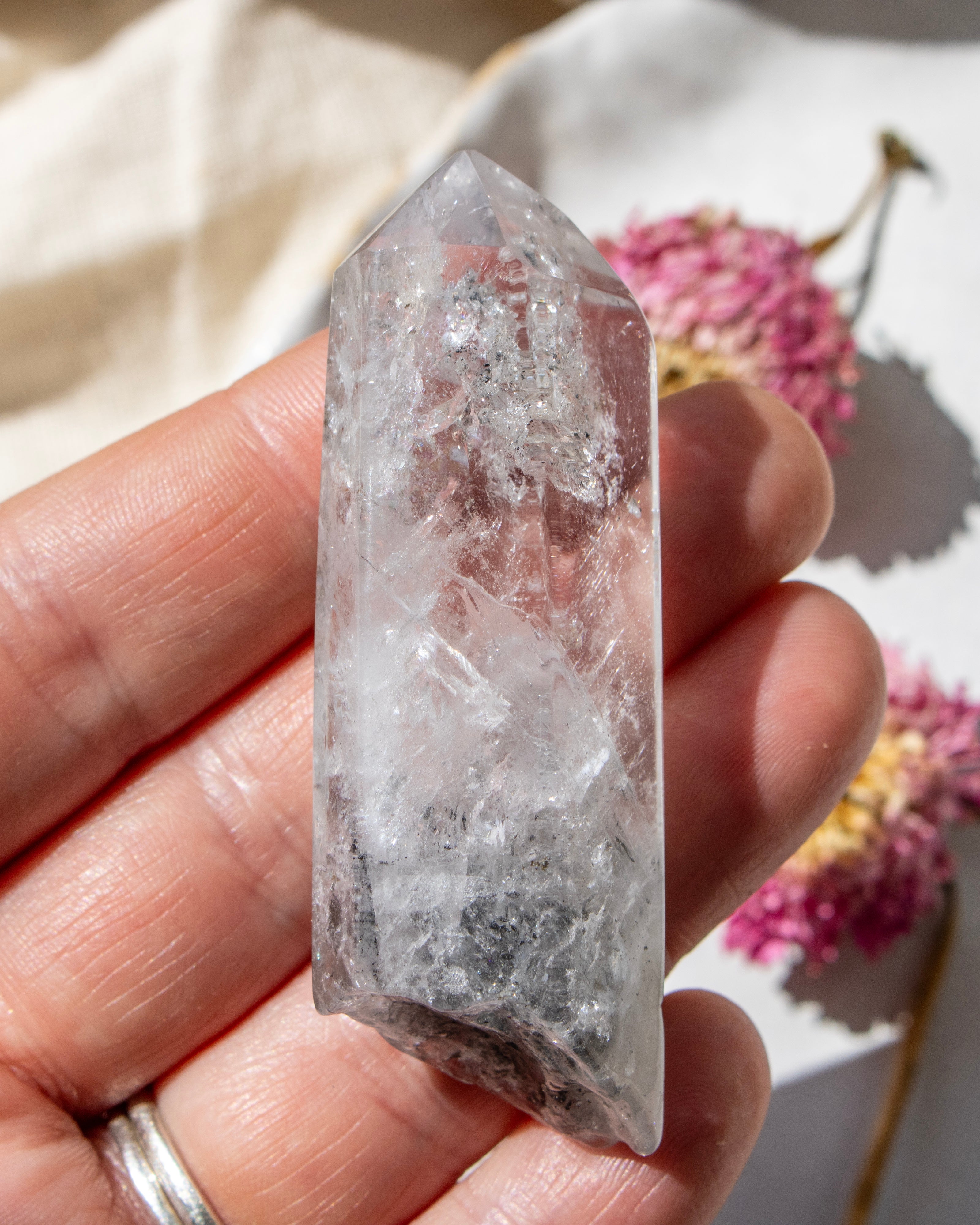 Clear crystal held in a hand with a soft background