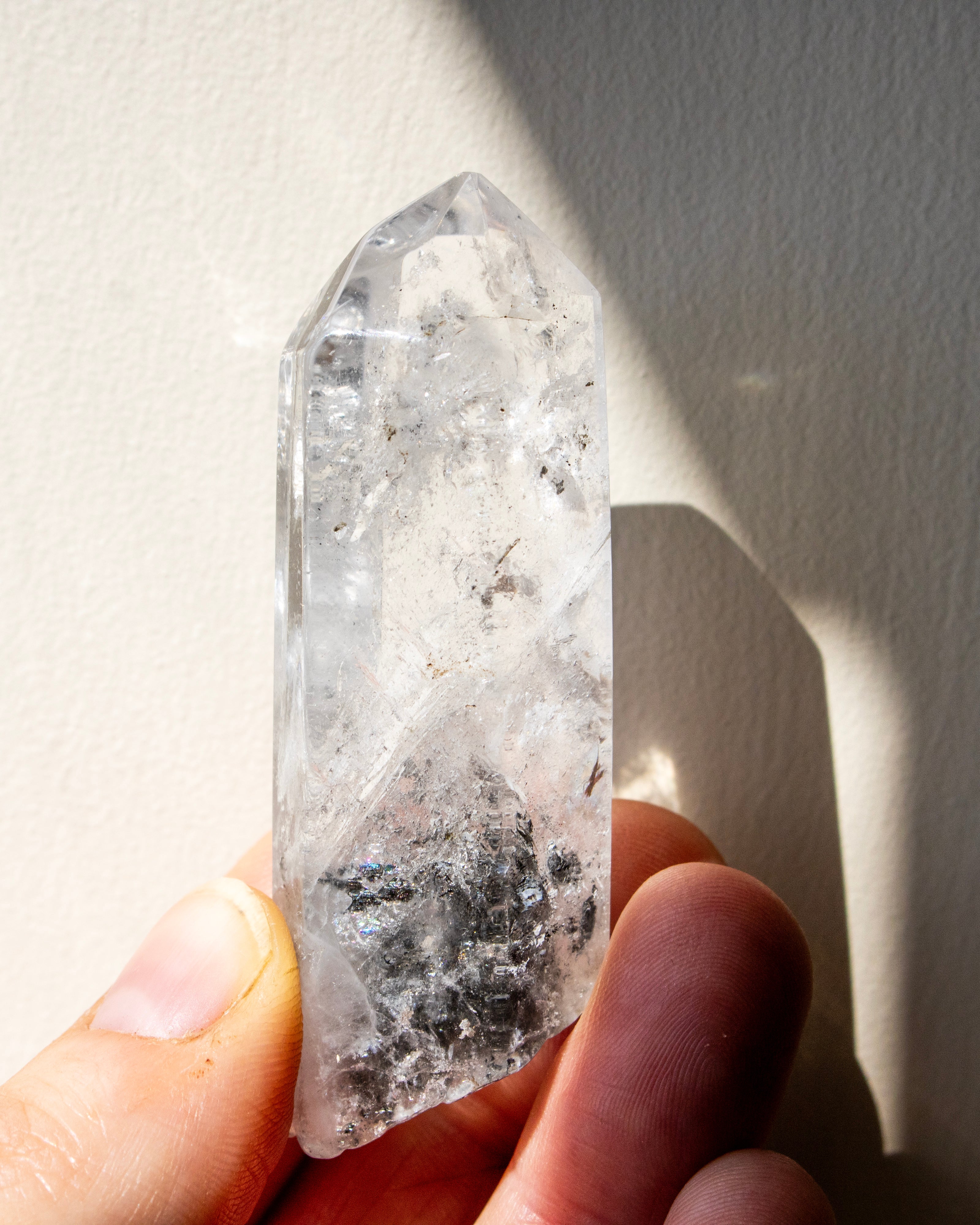 a clear crystal being held against a neutral background