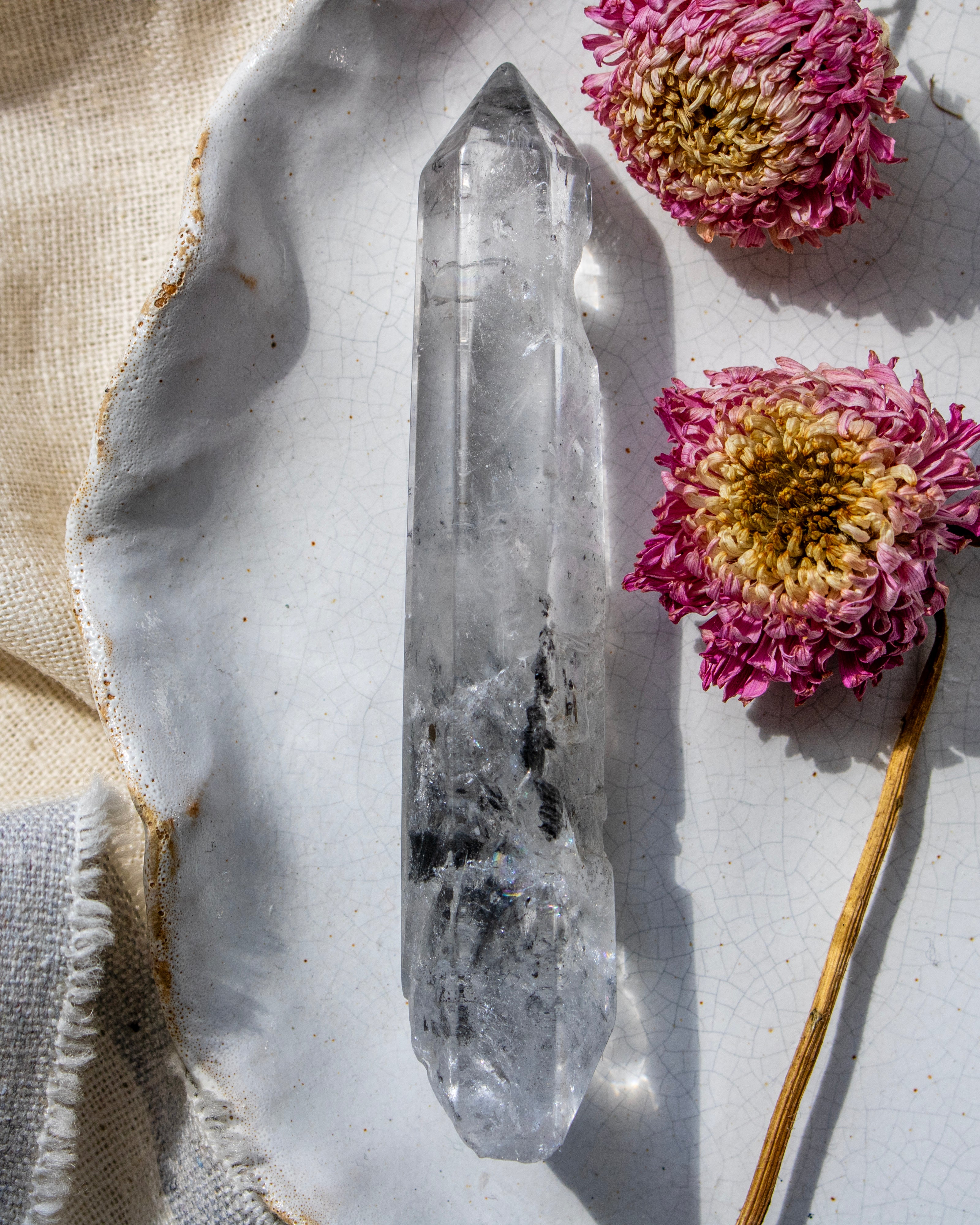 Crystal on a white stone surface with pink flowers