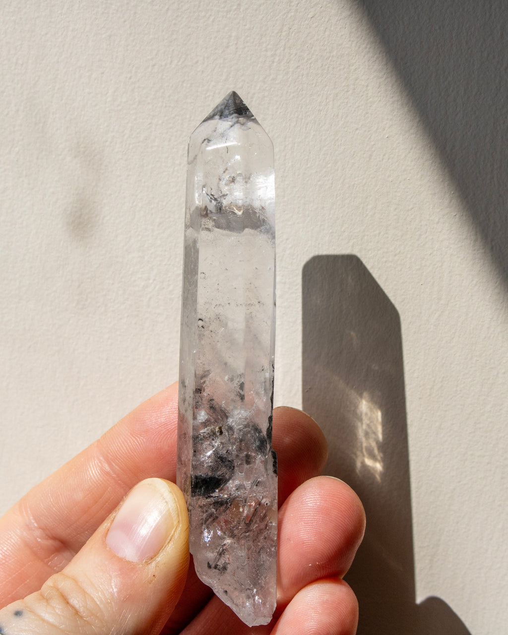 a clear crystal being held with a neutral background