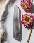 a clear crystal on a white ceramic plate with dried flowers
