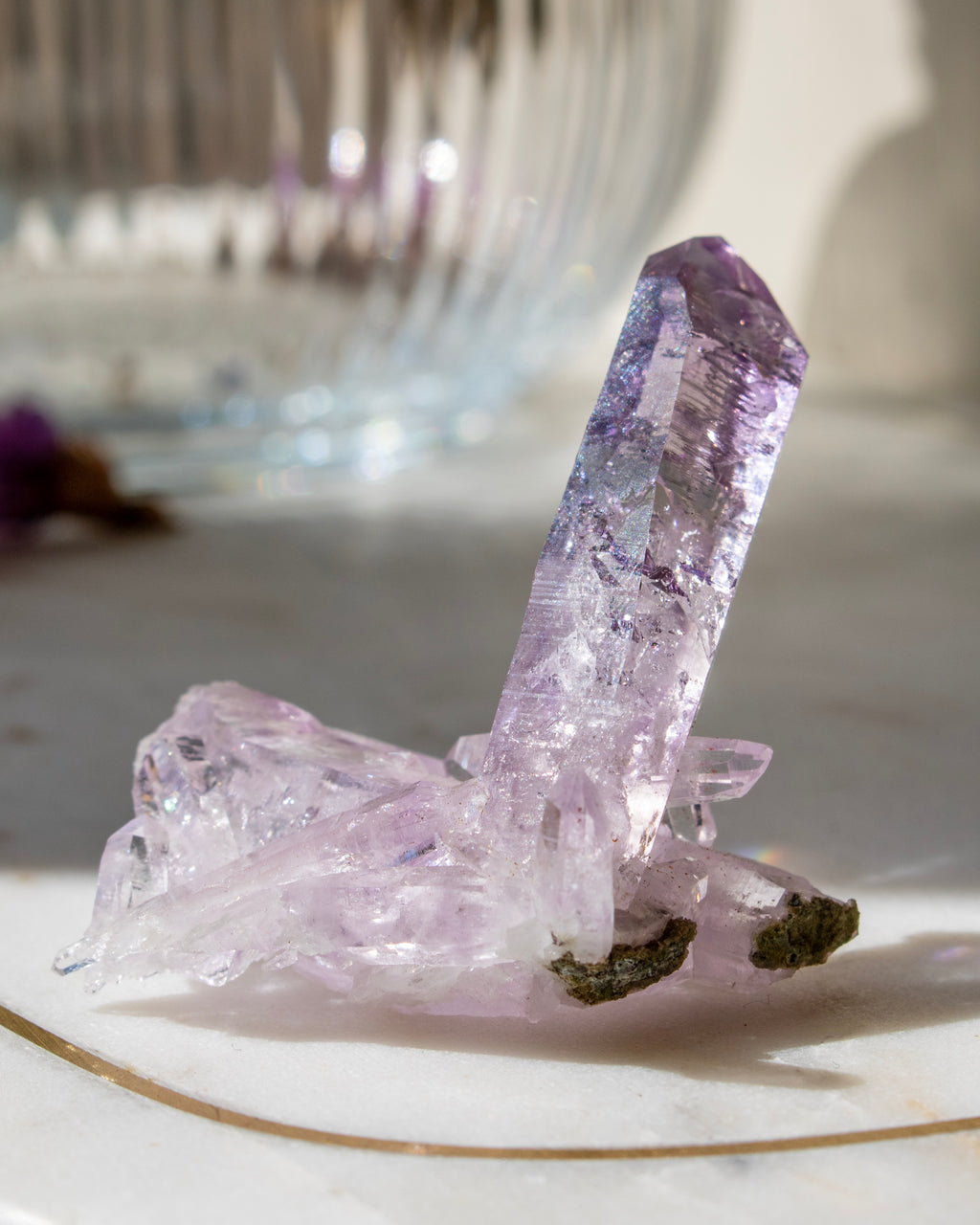 Amethyst crystal on a white surface with a blurred background