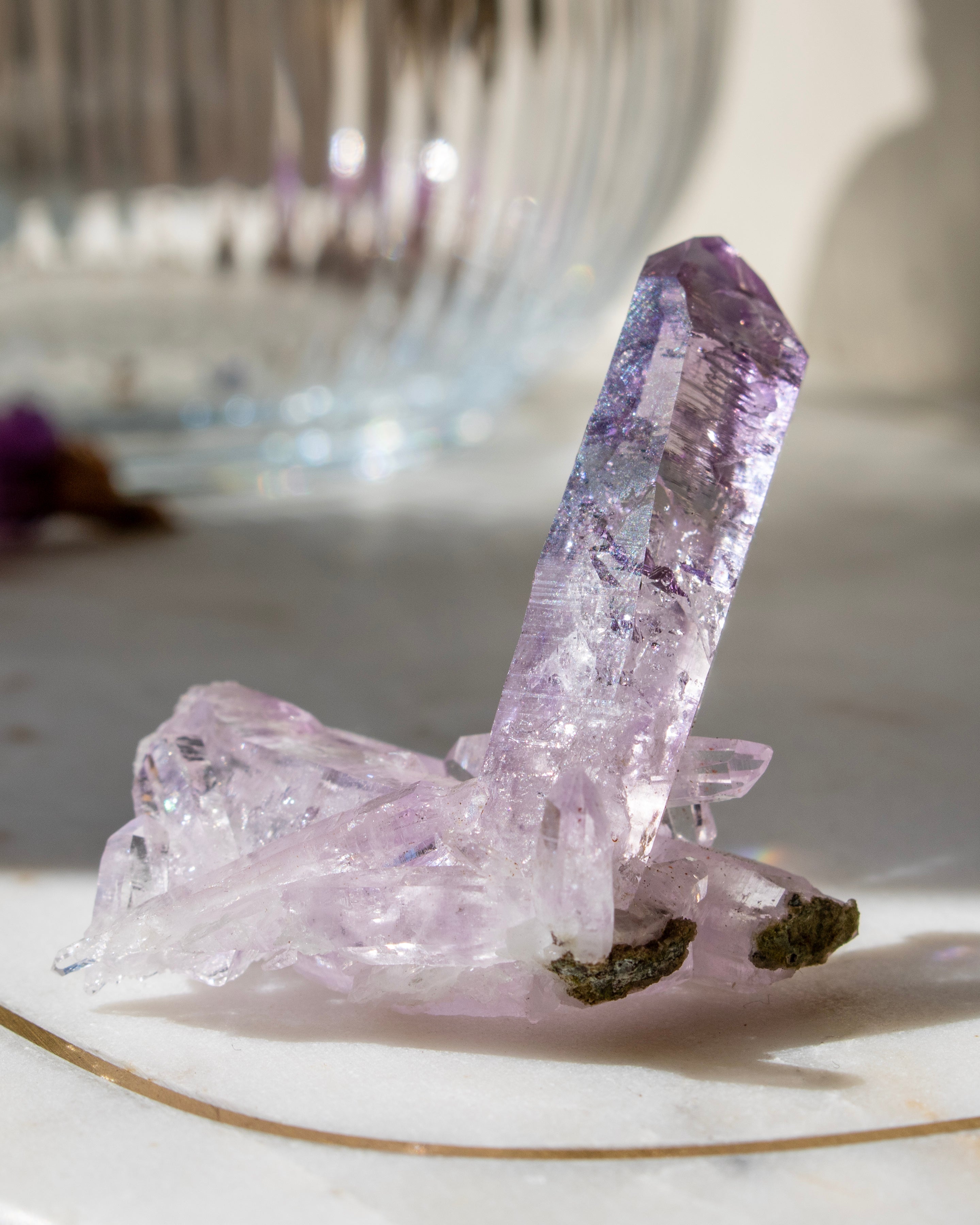 Amethyst crystal on a white surface with a blurred background