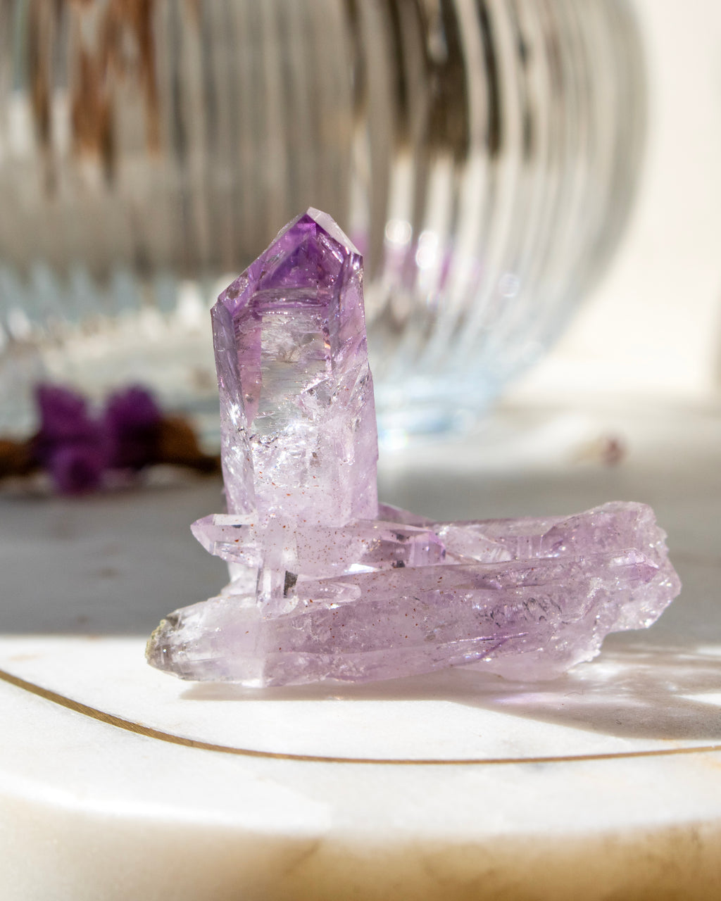 Amethyst crystal on a marble surface with a blurred background