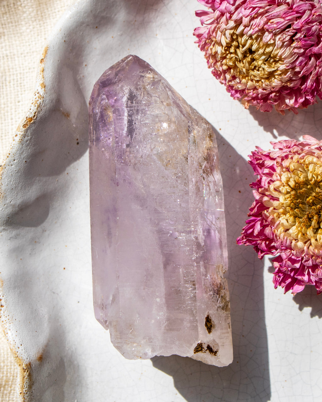 Crystal with a natural light background and pink flowers