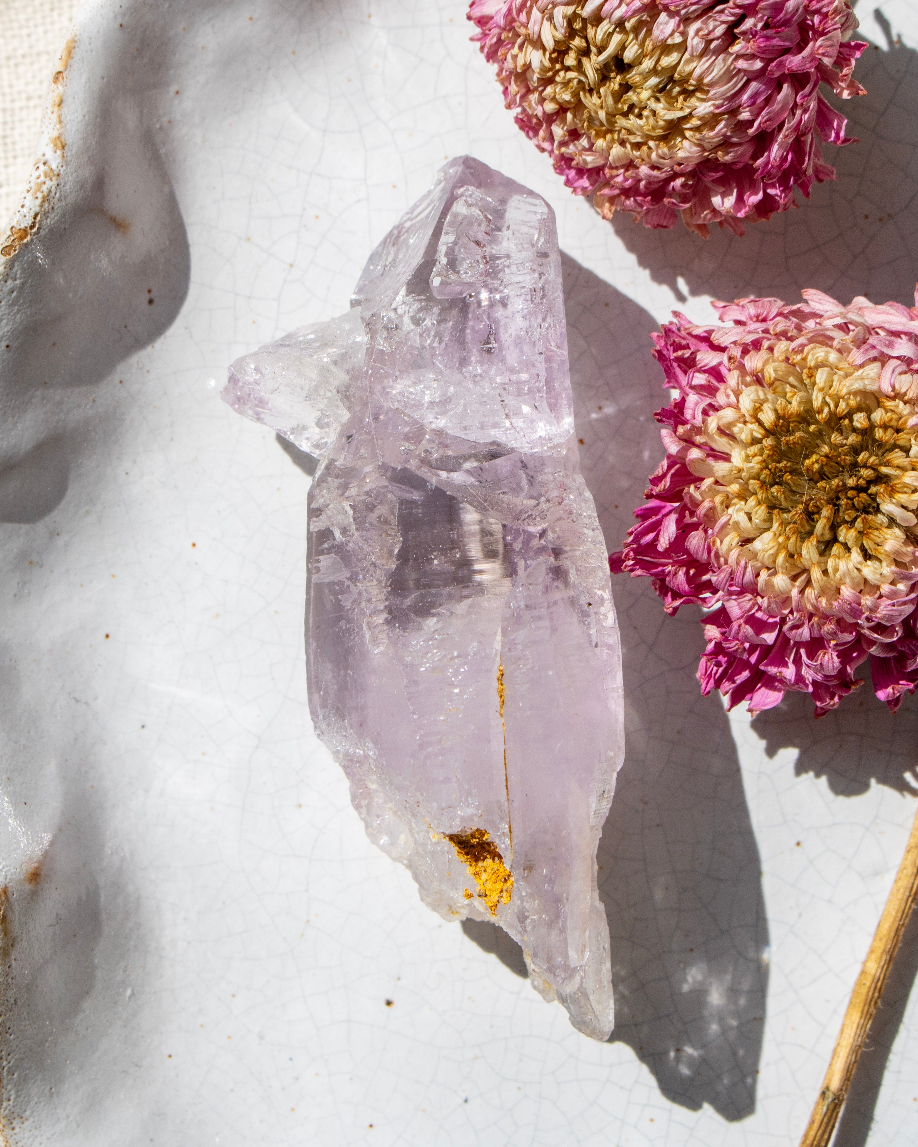 Crystal on a white surface with pink flowers