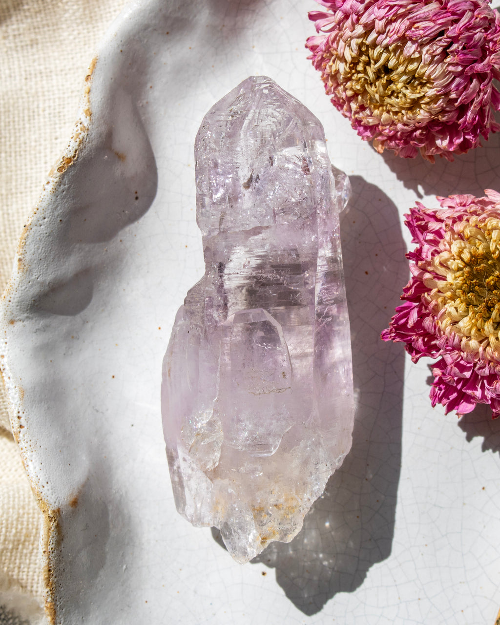 Crystal on a white surface with pink flowers
