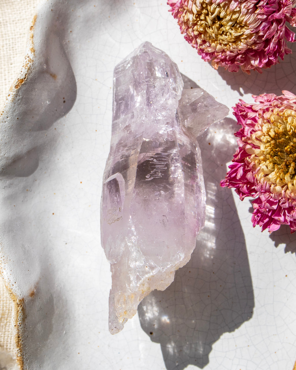 Crystal on a textured surface with pink flowers