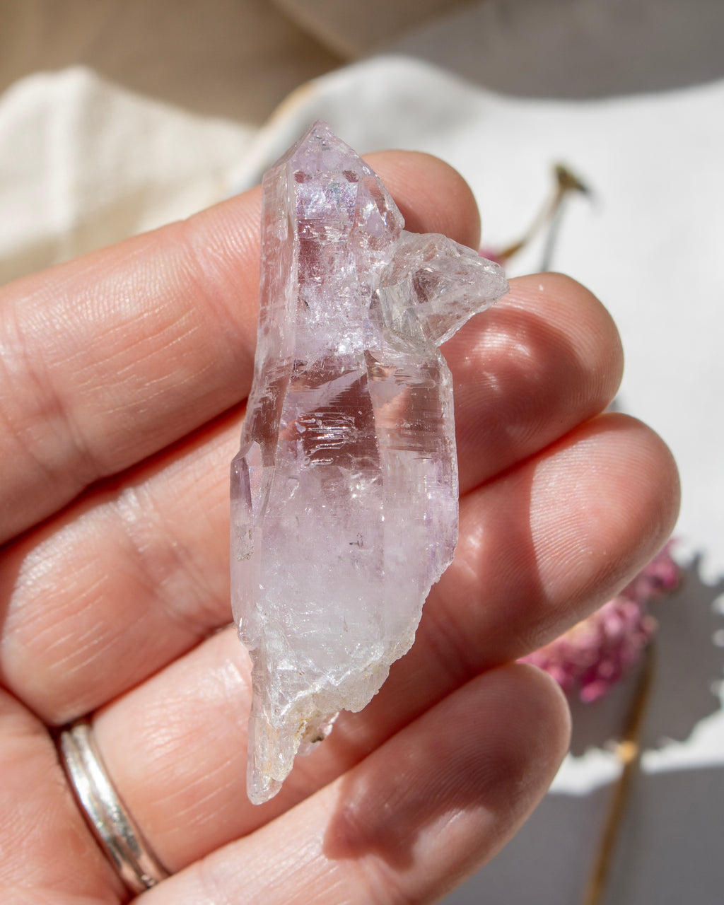 Clear crystal held in a hand with a soft background