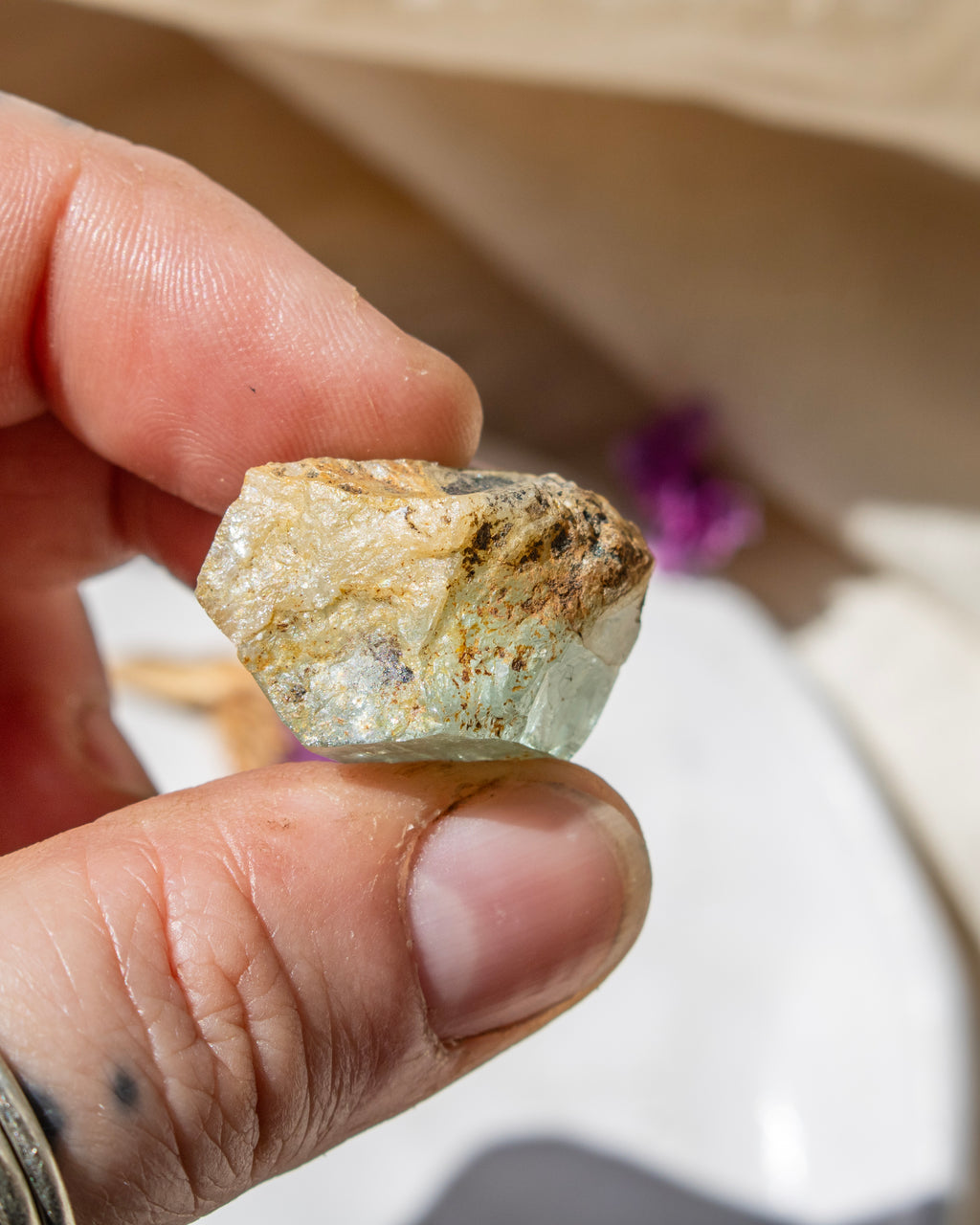 Hand holding a rough crystal rock with a blurred background