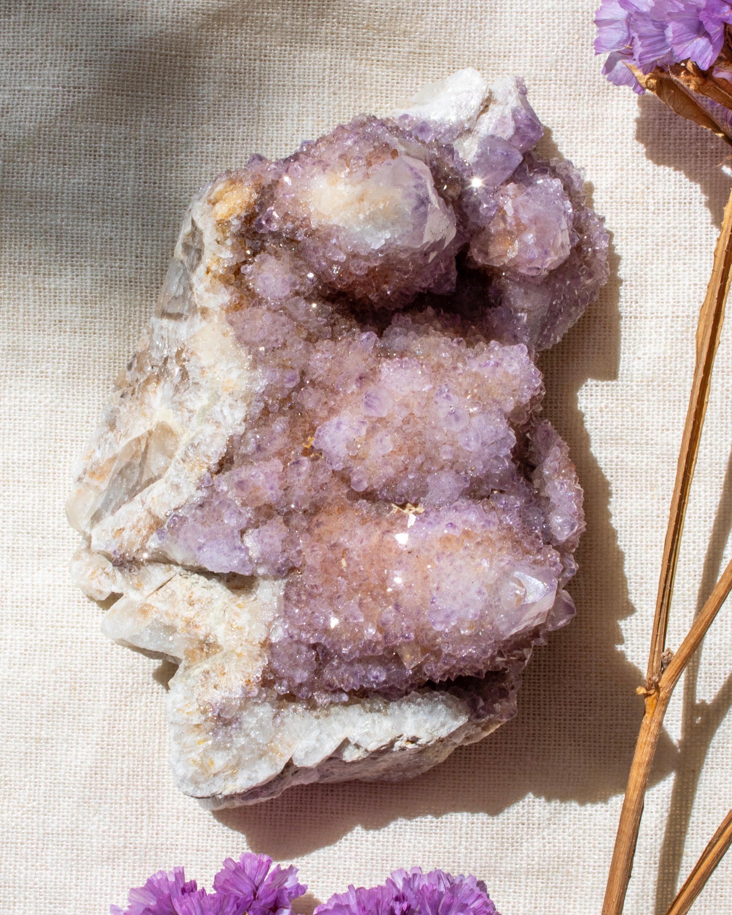 purple crystal cluster on a beige textured fabric