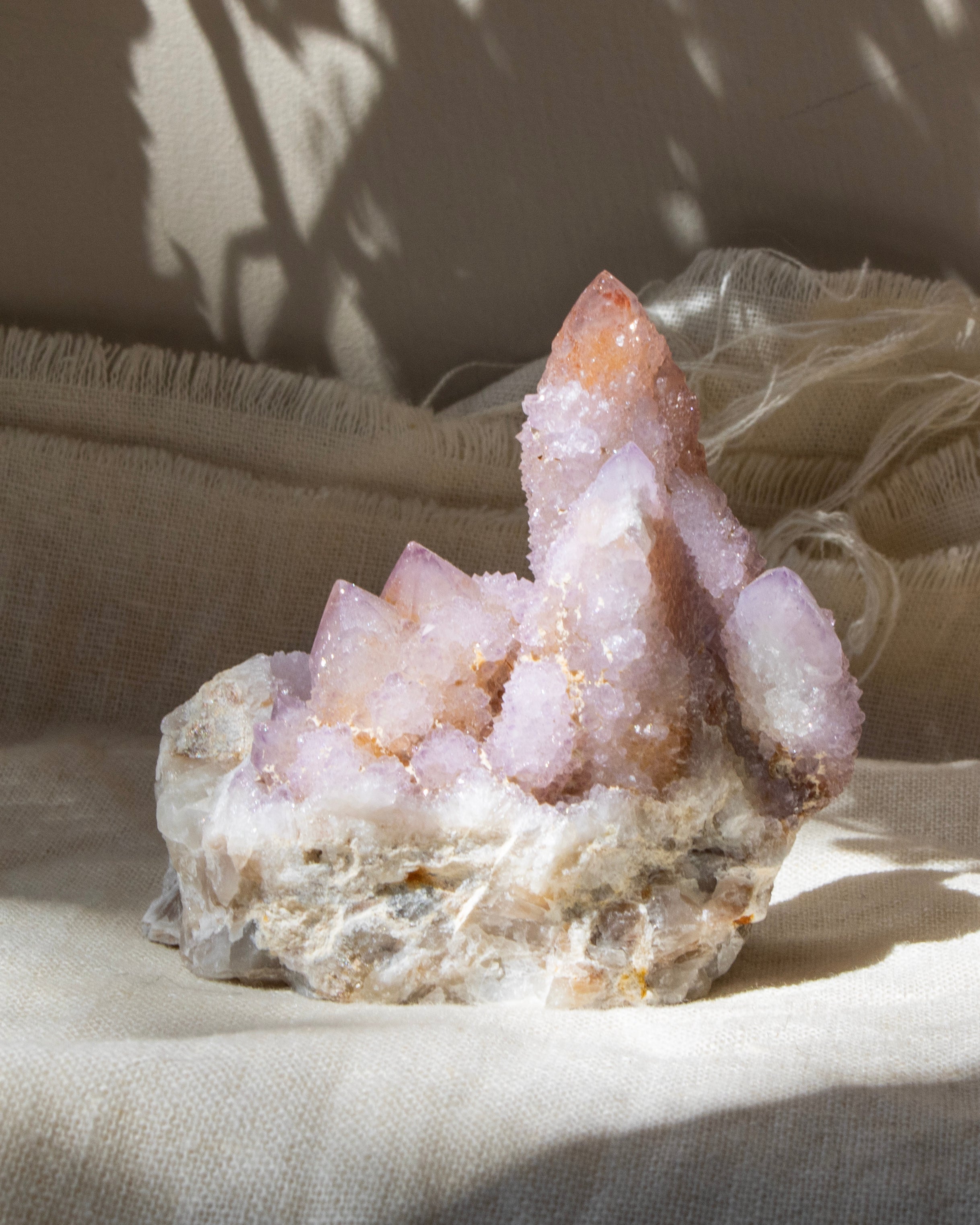 Pink crystal formation on a beige fabric background
