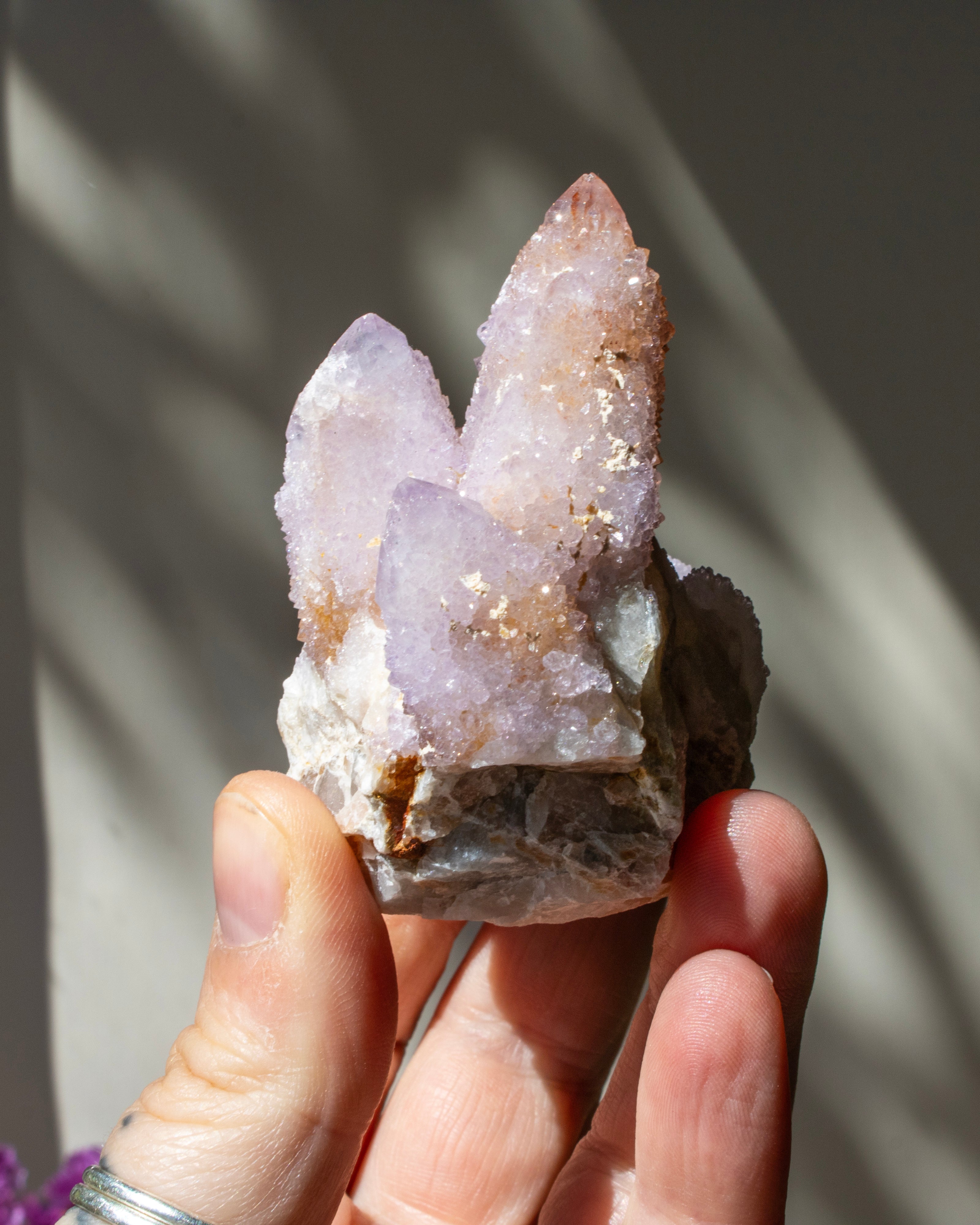 Hand holding a crystal formation with a blurred background