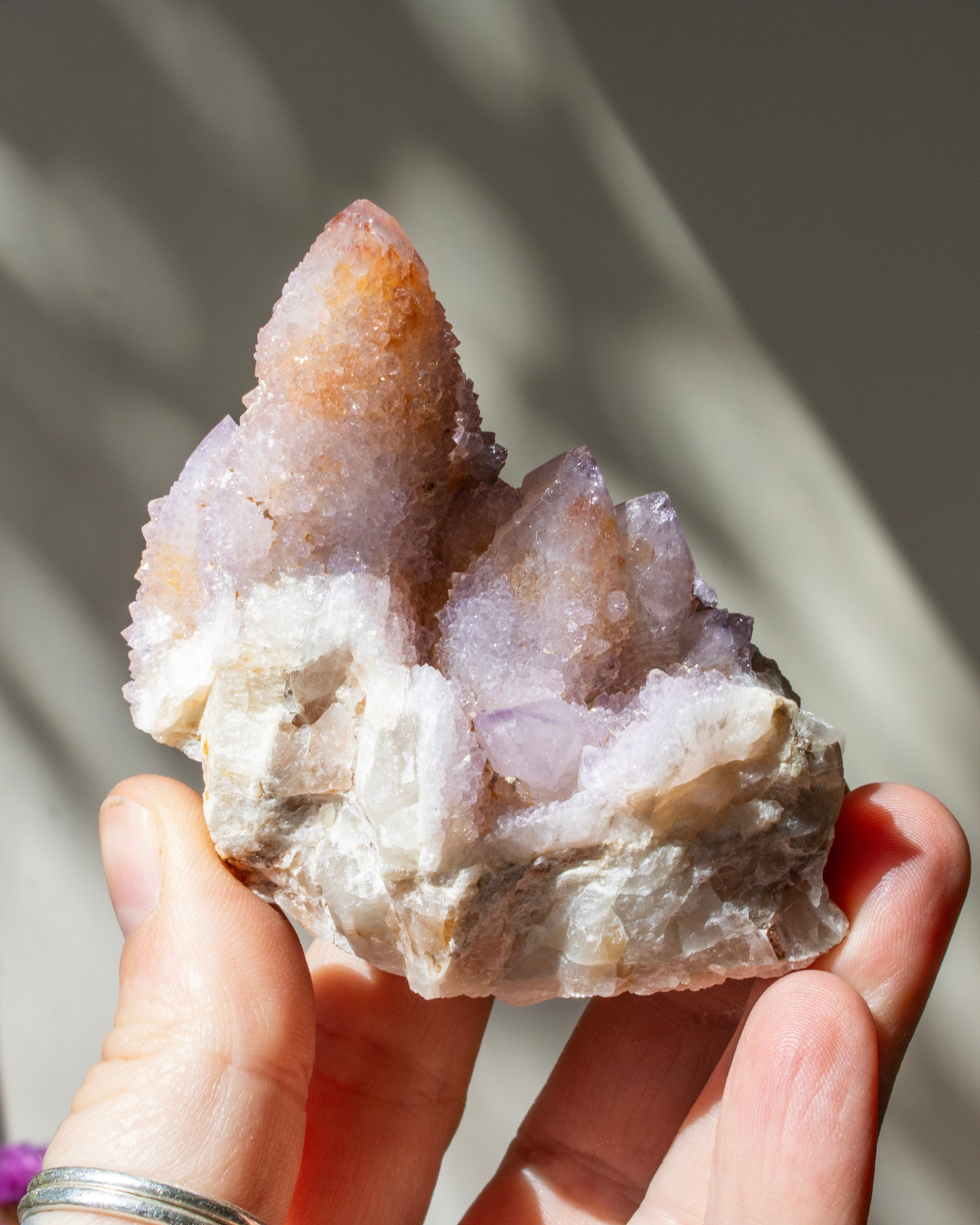 Hand holding a crystal formation with a blurred background