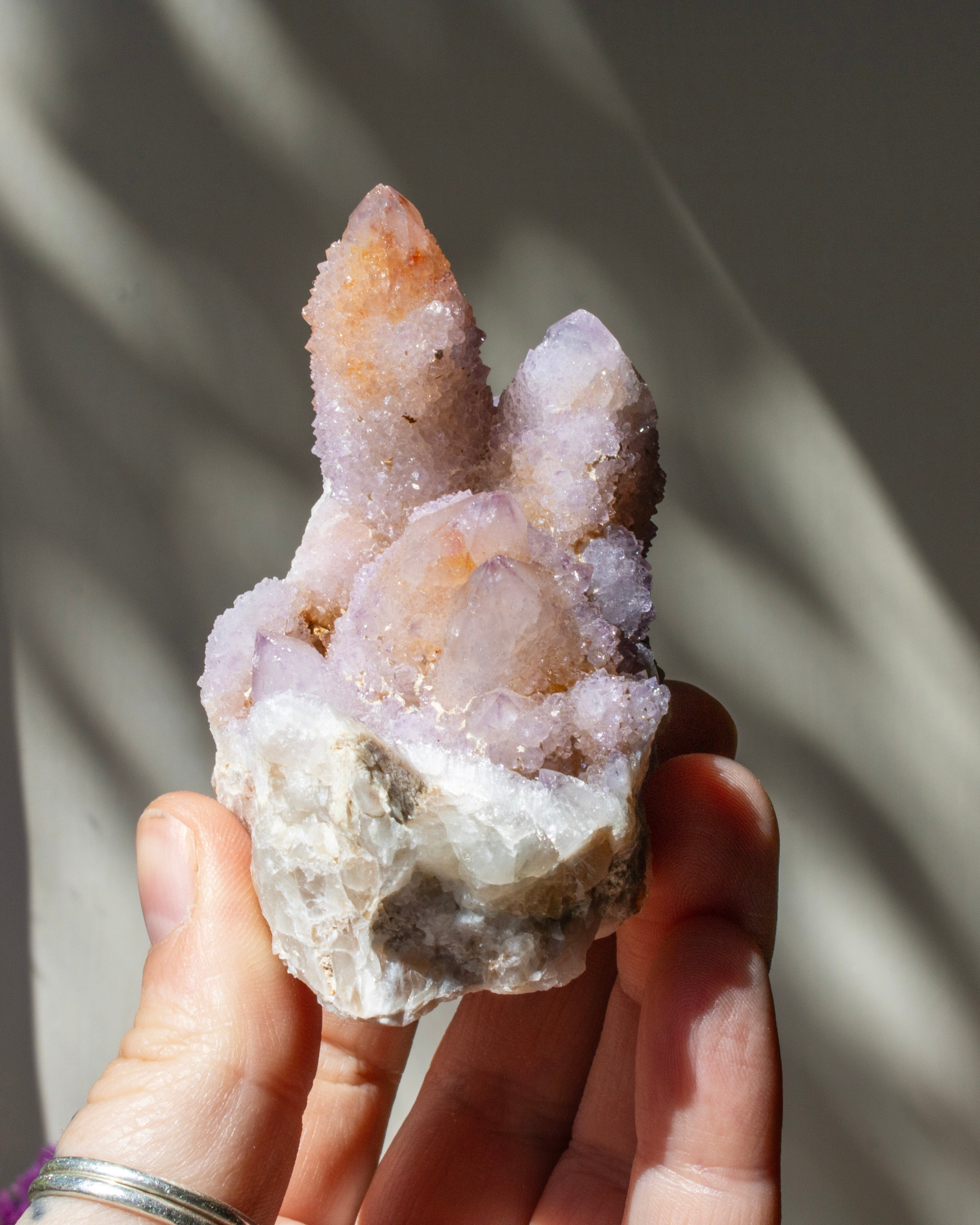 Hand holding a crystal formation with a blurred background