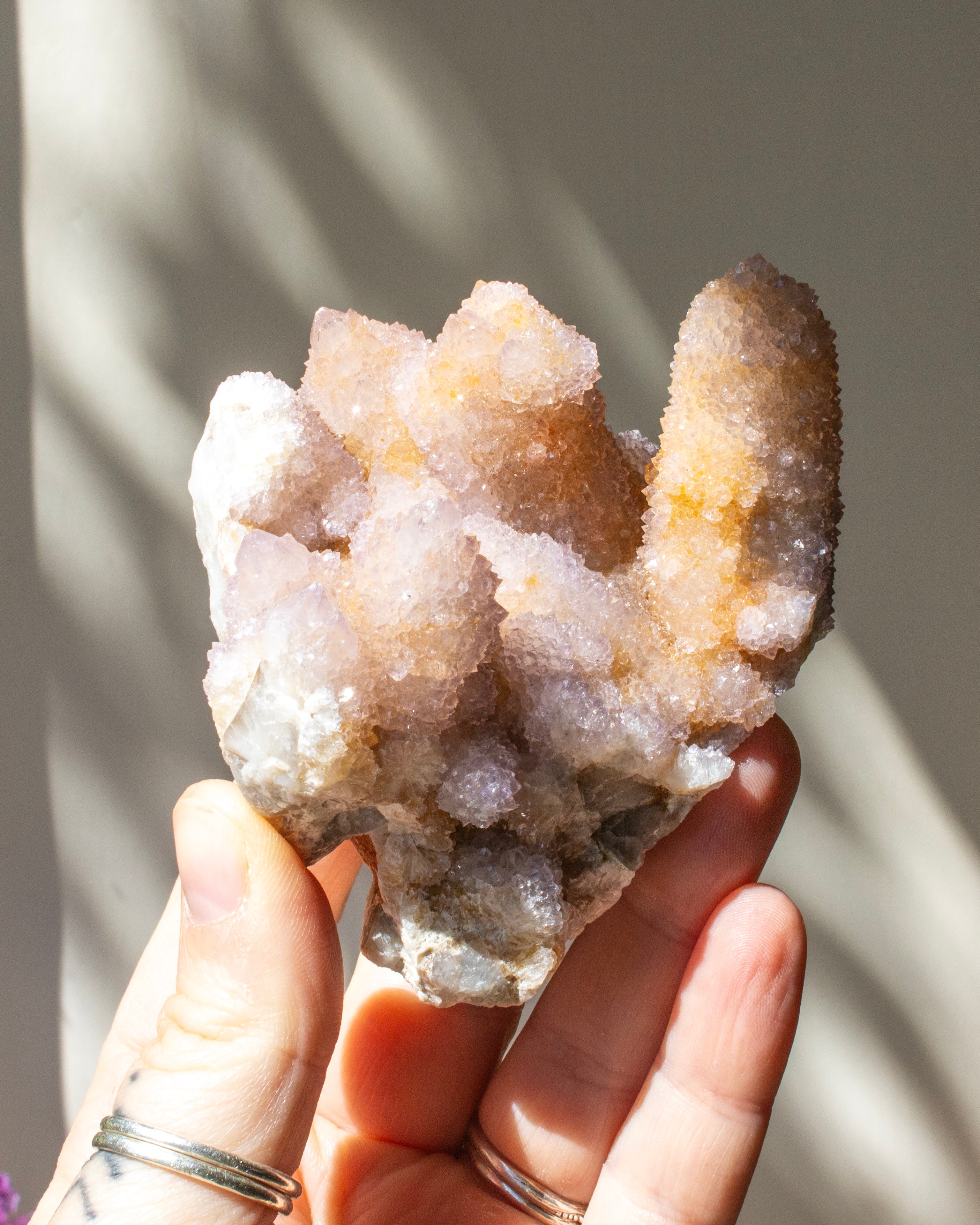 Hand holding a crystal cluster with a blurred background