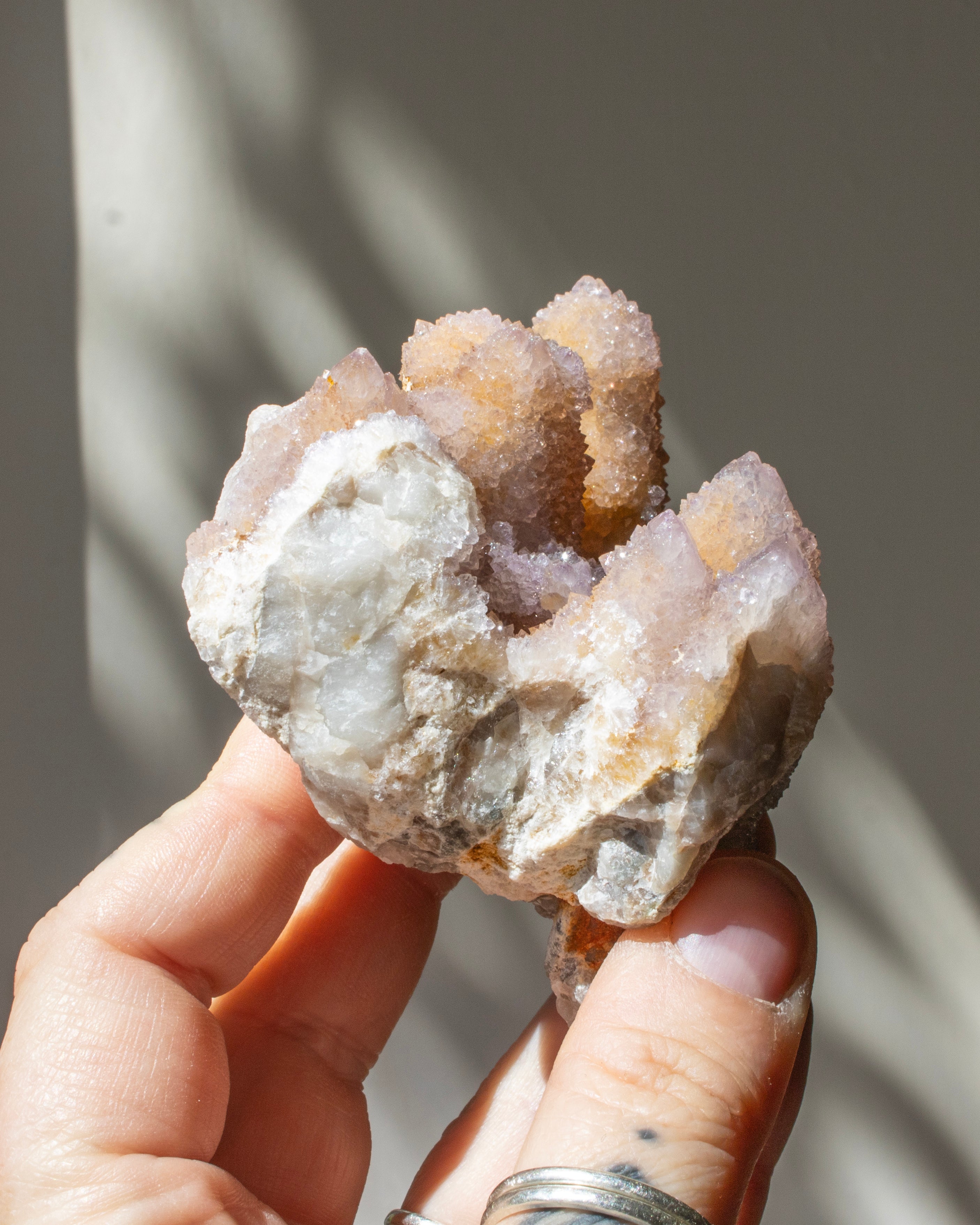 Hand holding a crystal rock with a blurred natural background