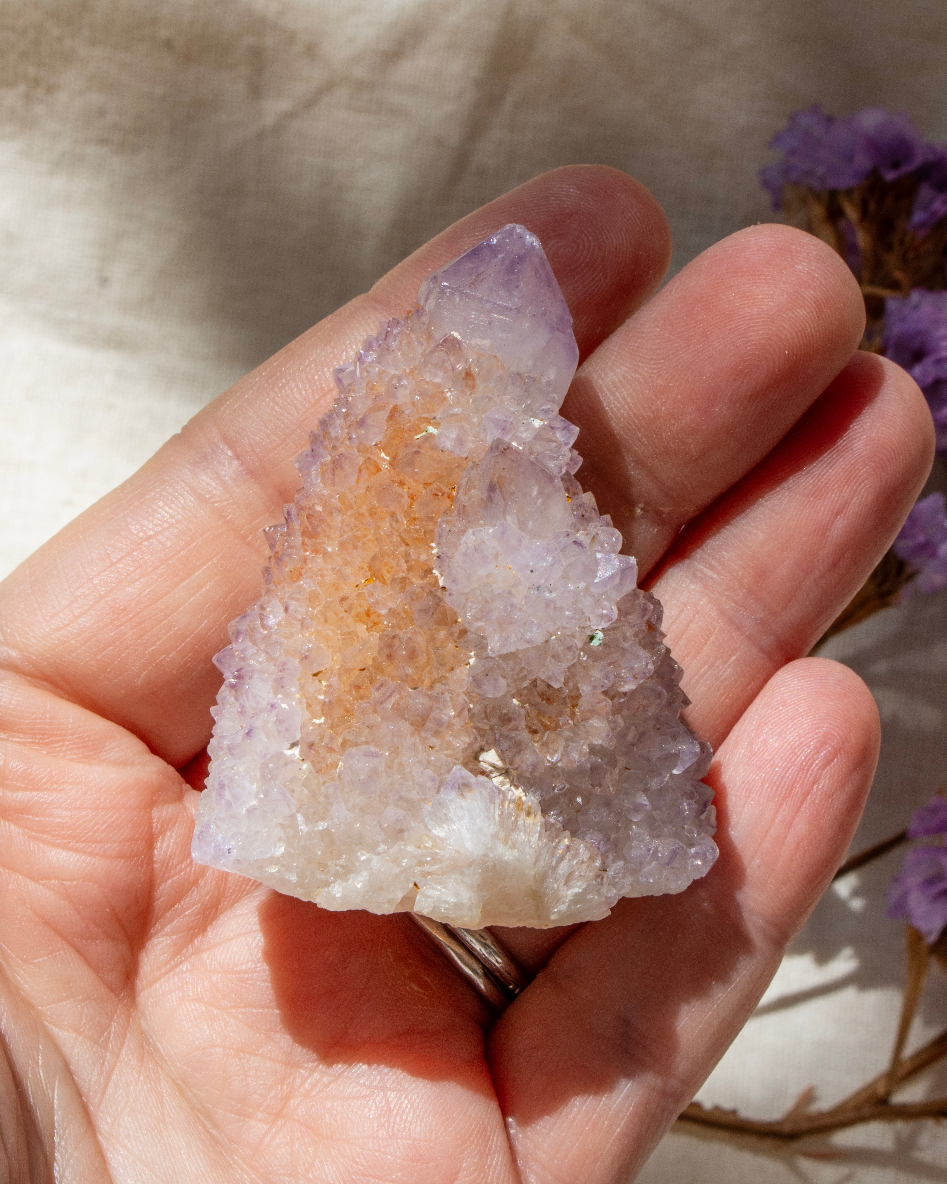 Hand holding a crystal geode with a blurred natural background