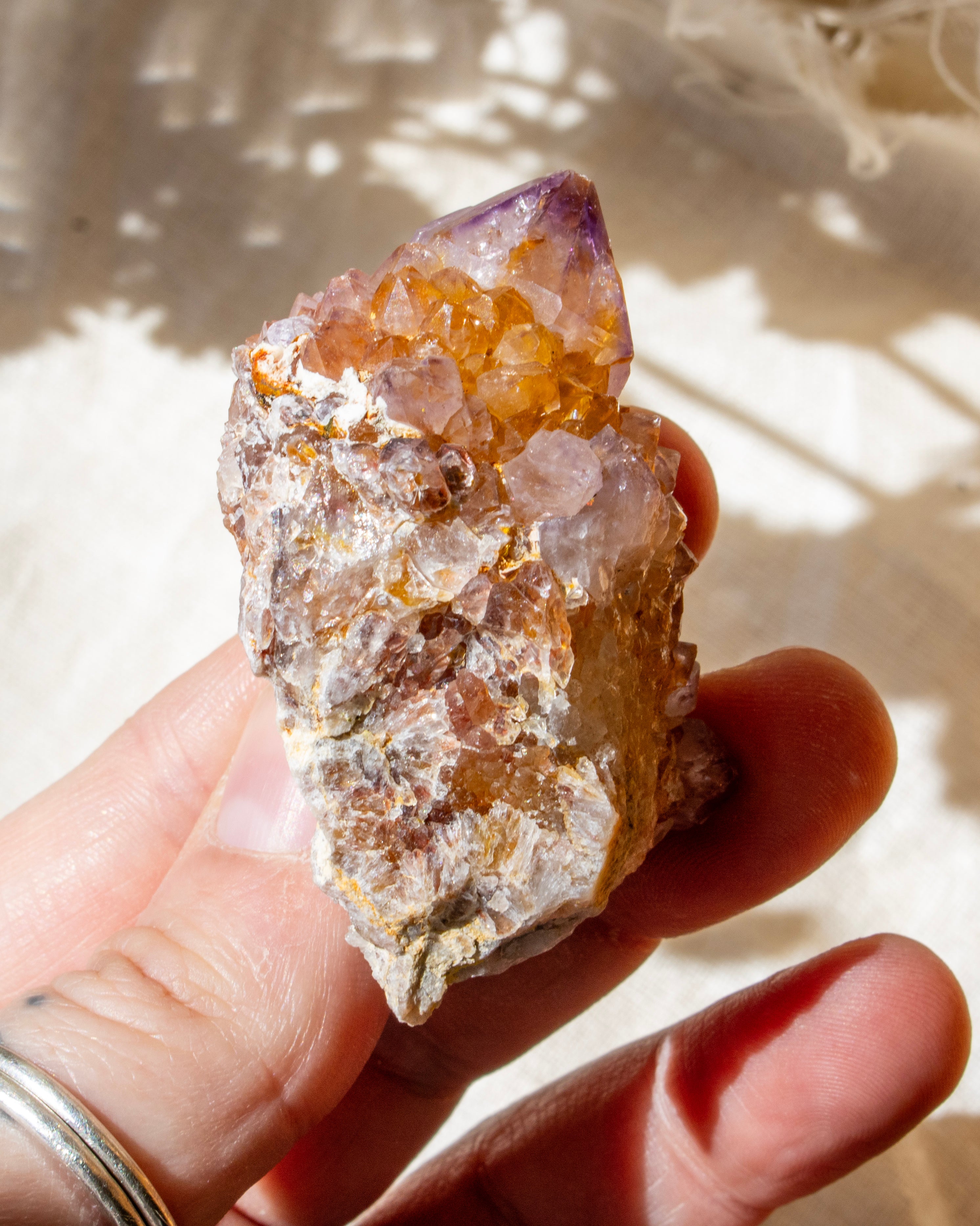Hand holding a crystal with a natural background