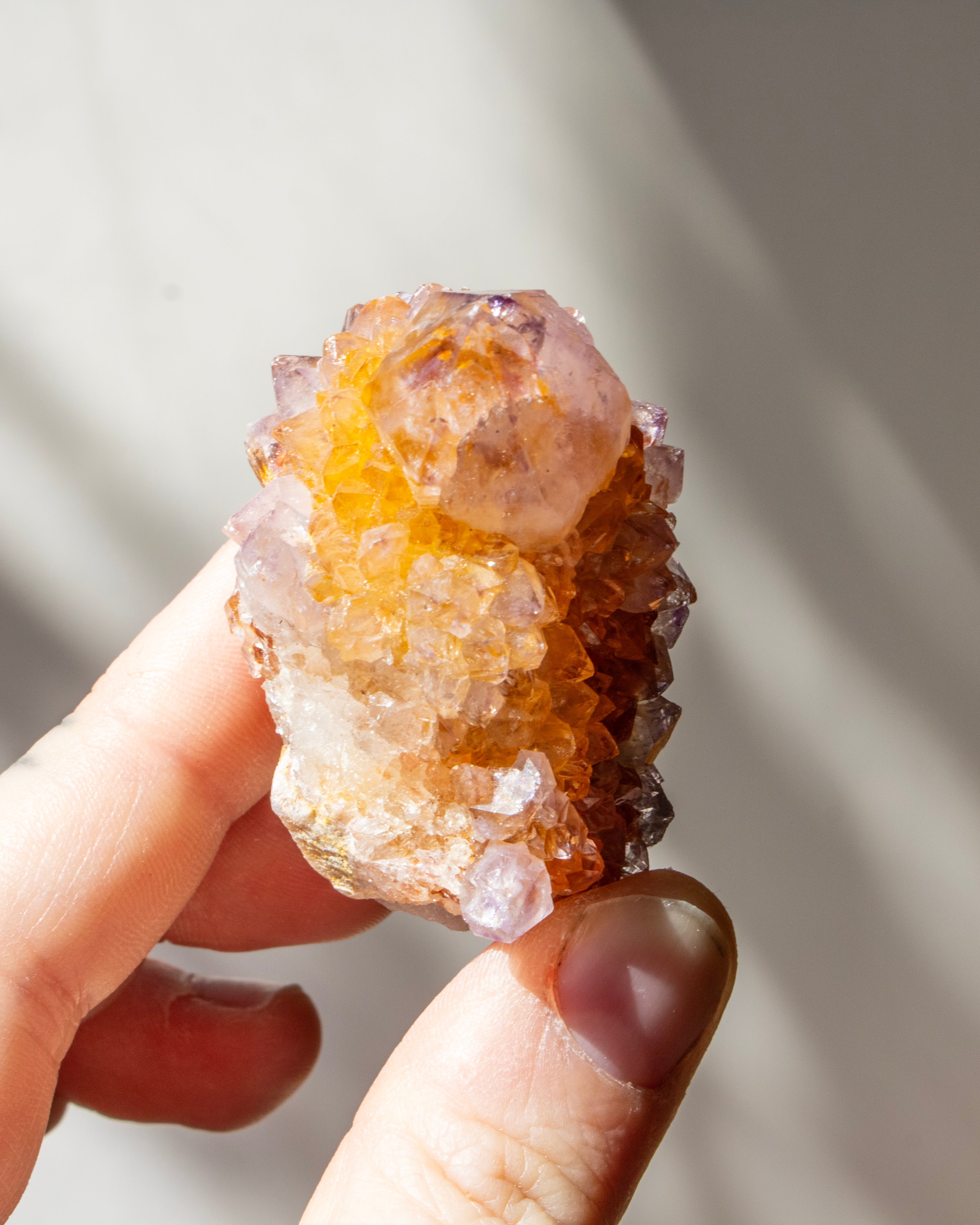 Hand holding a crystal with a natural background