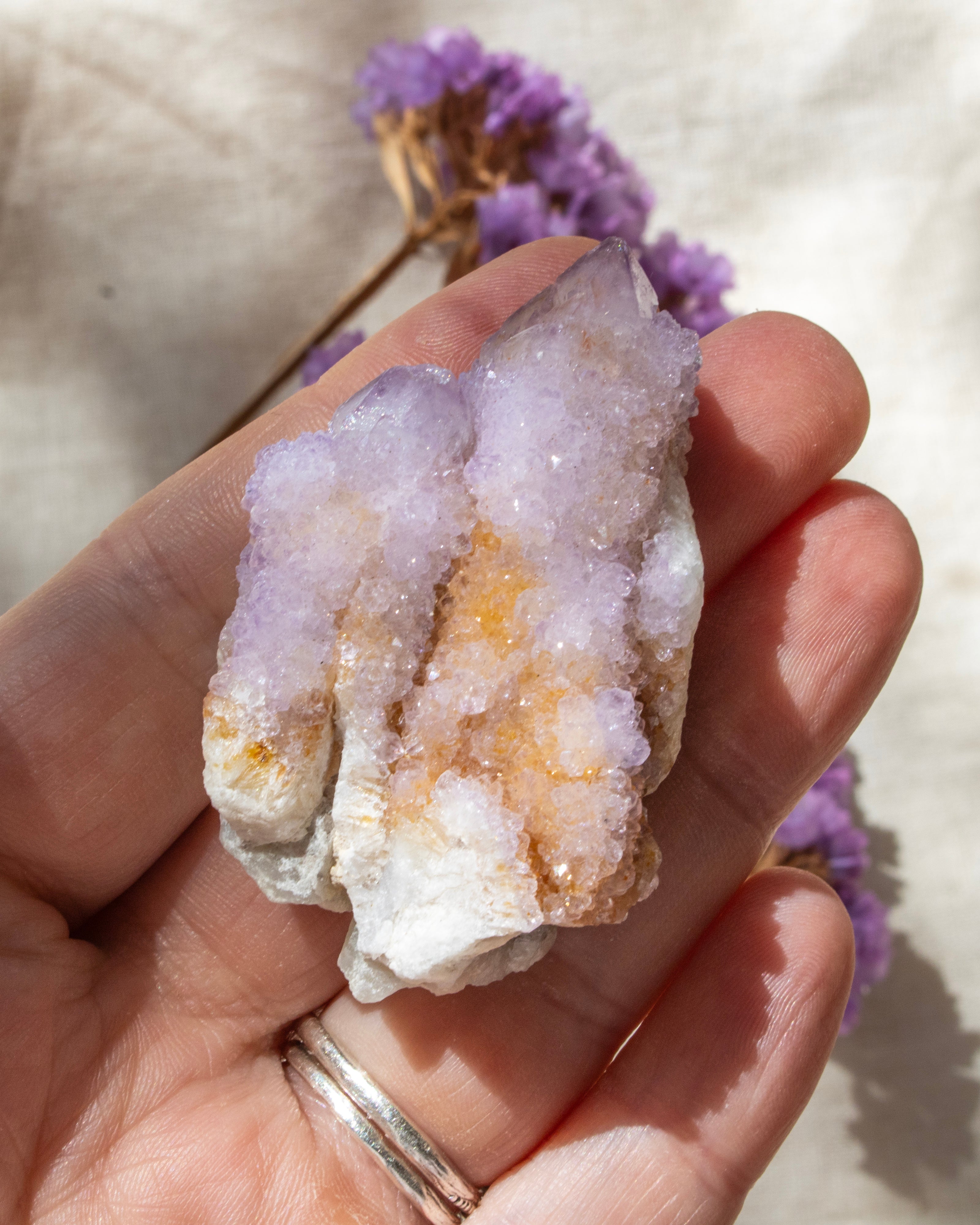 hand holding a purple crystal cluster with a blurred background