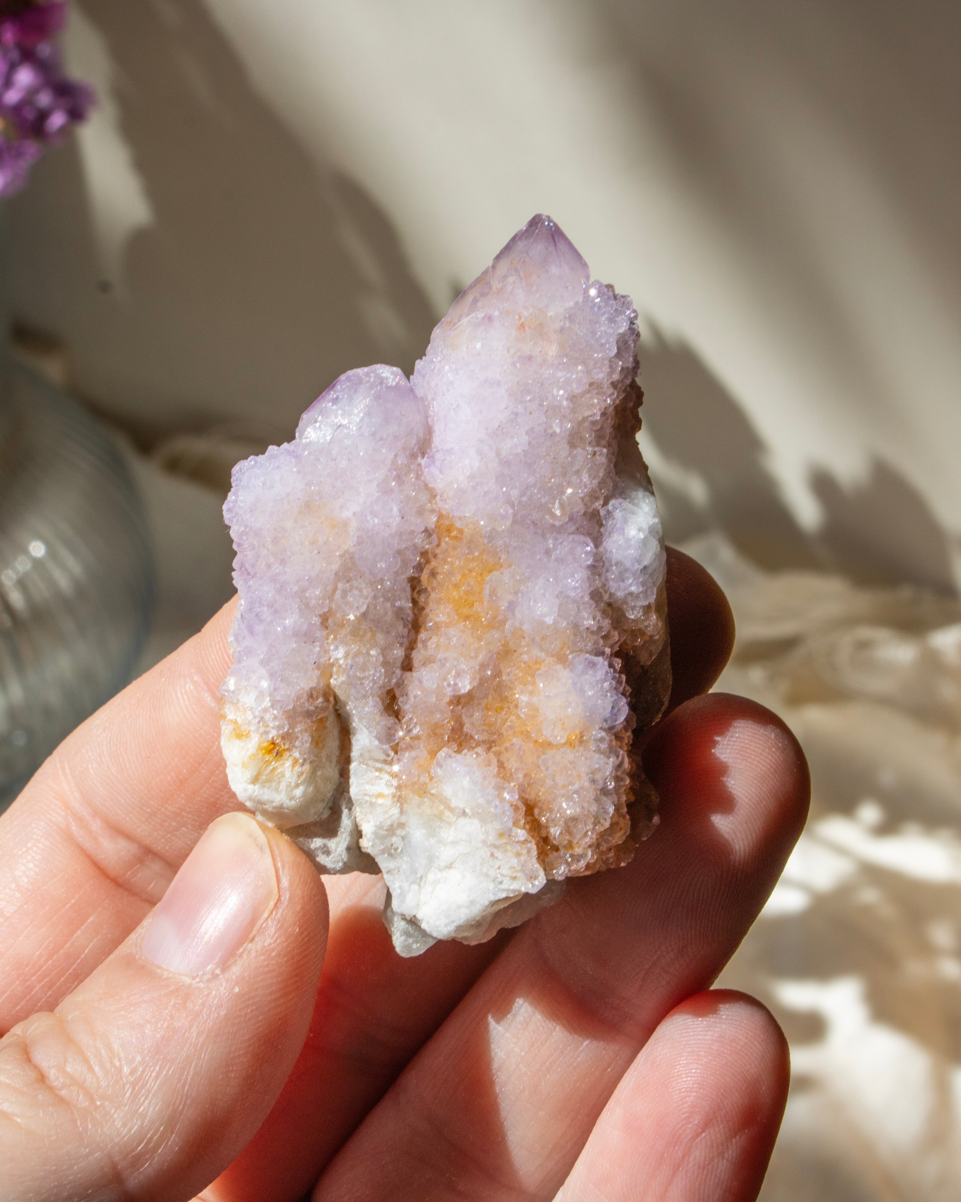 hand holding a purple crystal cluster with a blurred background