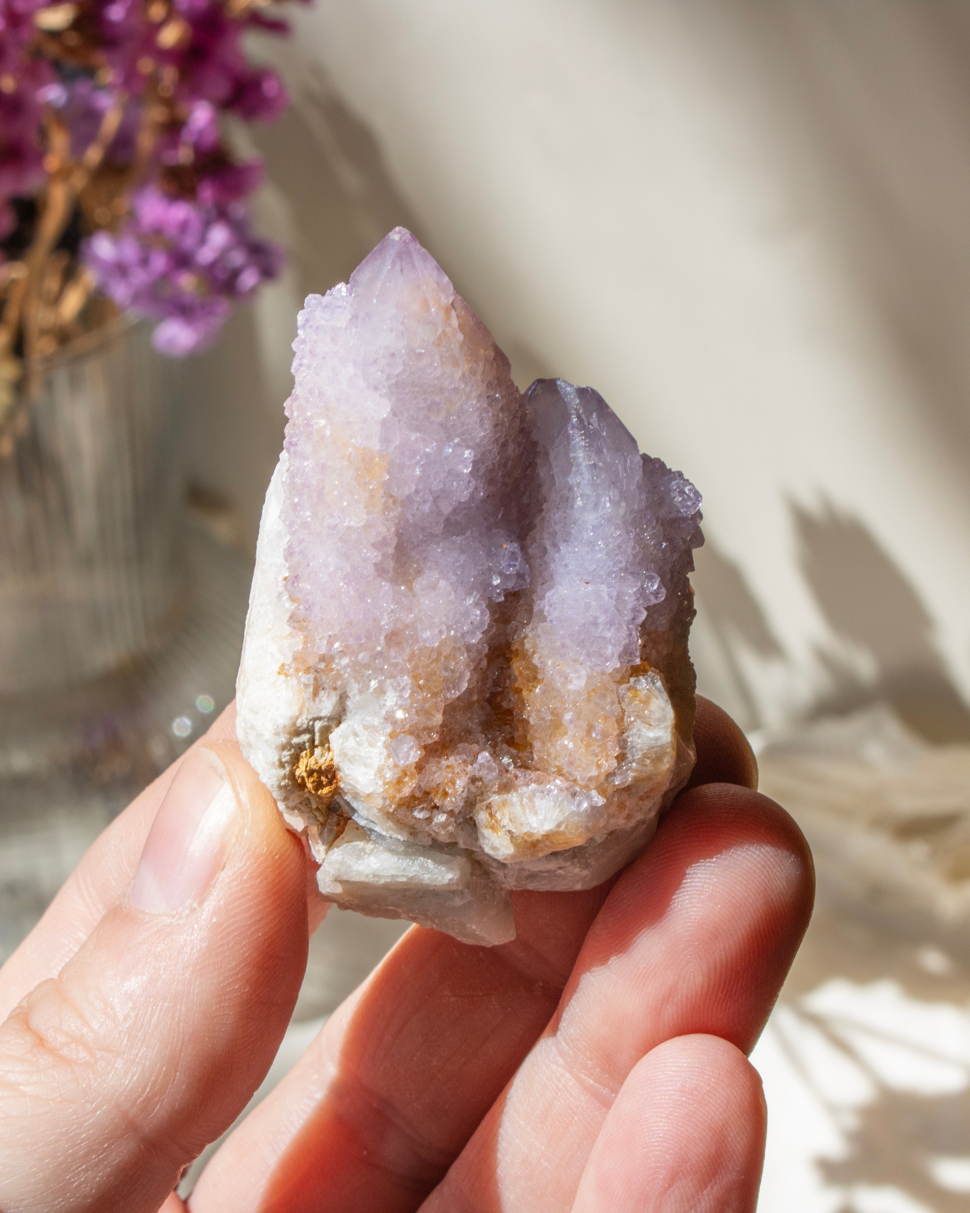Hand holding a crystal with a soft focus background