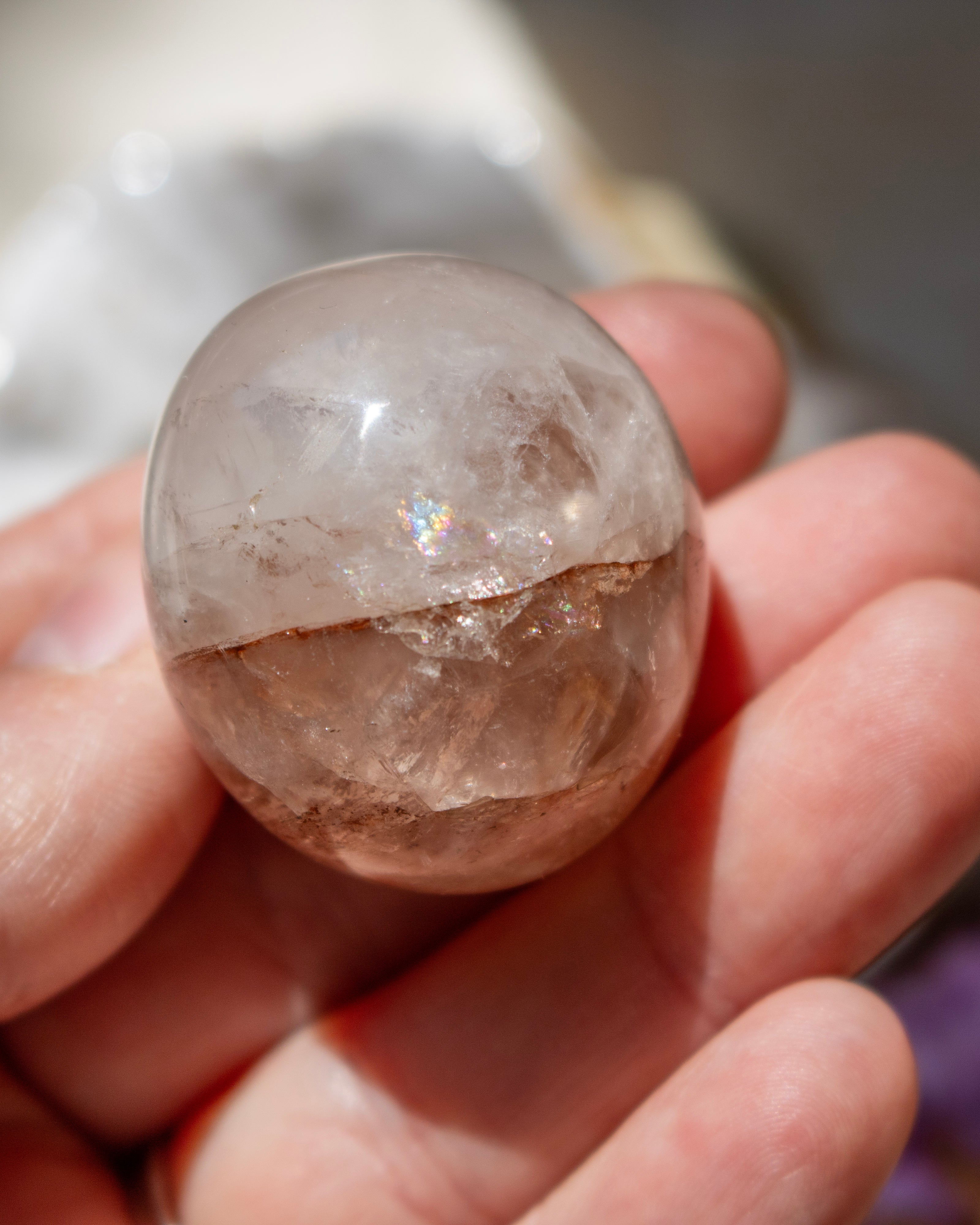 Clear crystal ball held in a hand with a blurred background