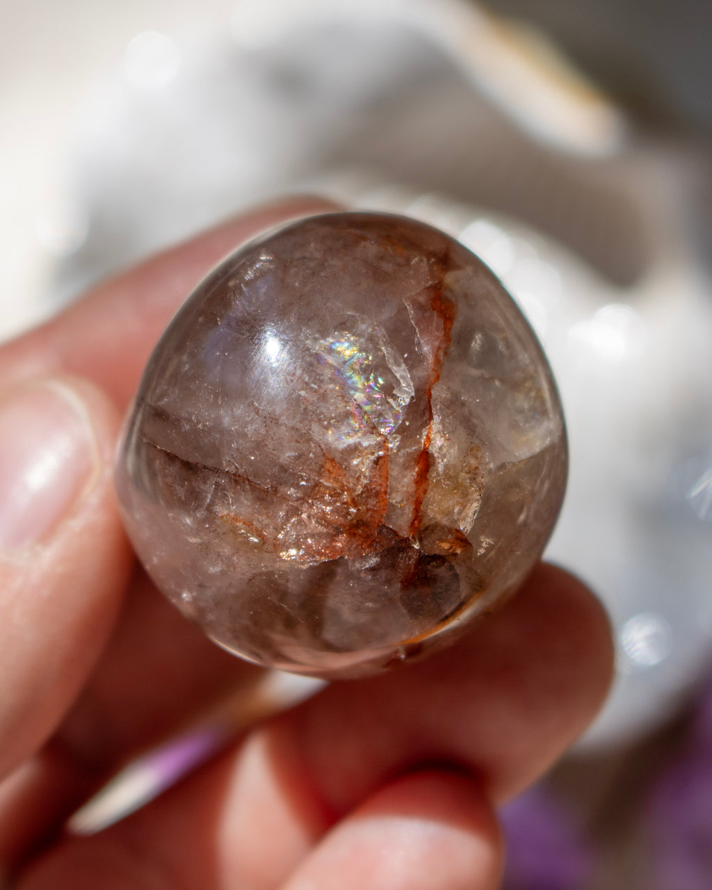 Crystal held in a hand with a blurred background