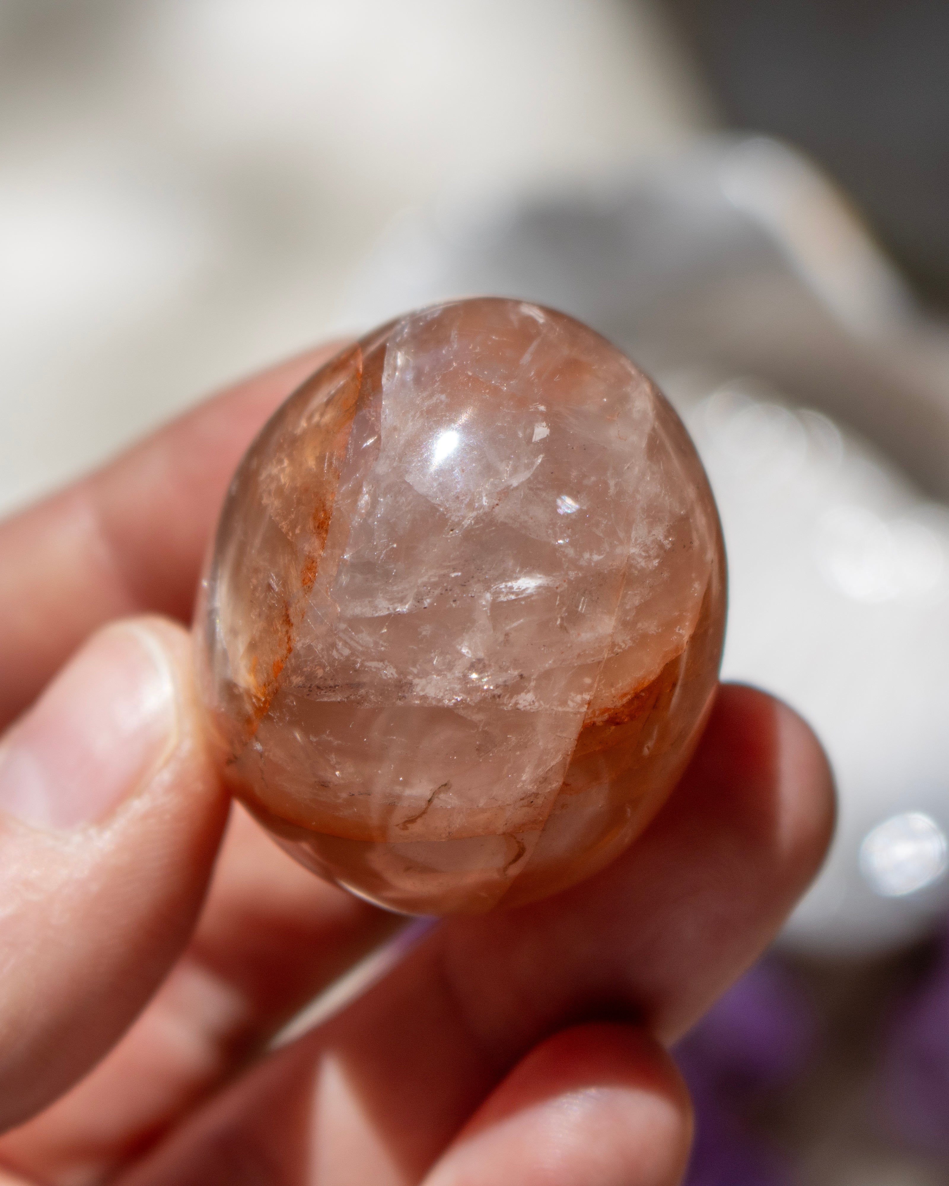 Hand holding a rough crystal stone with a blurred background