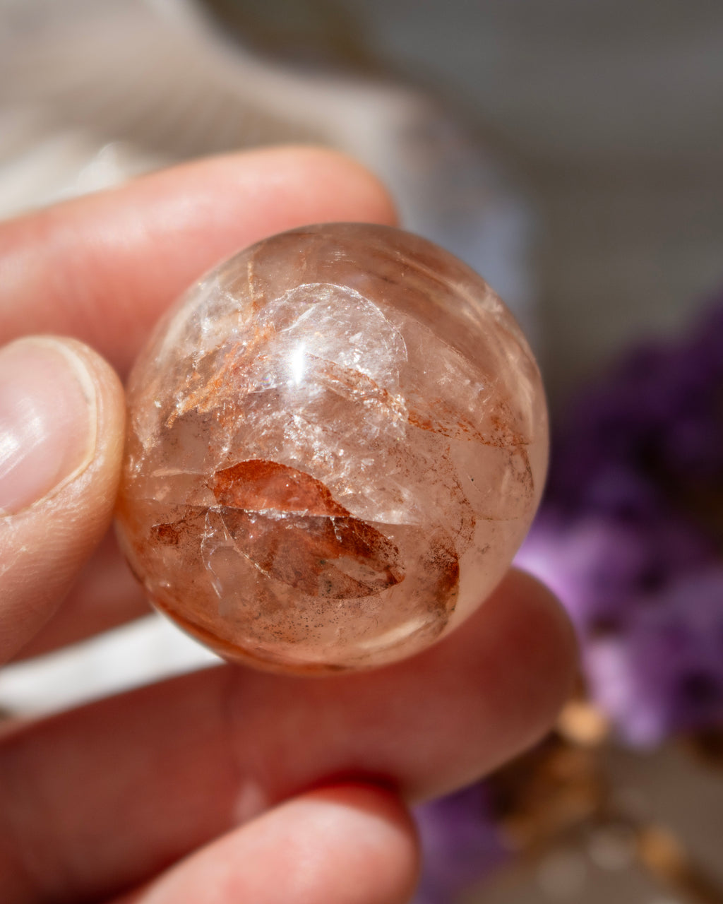 Clear crystal ball held in a hand with a blurred background