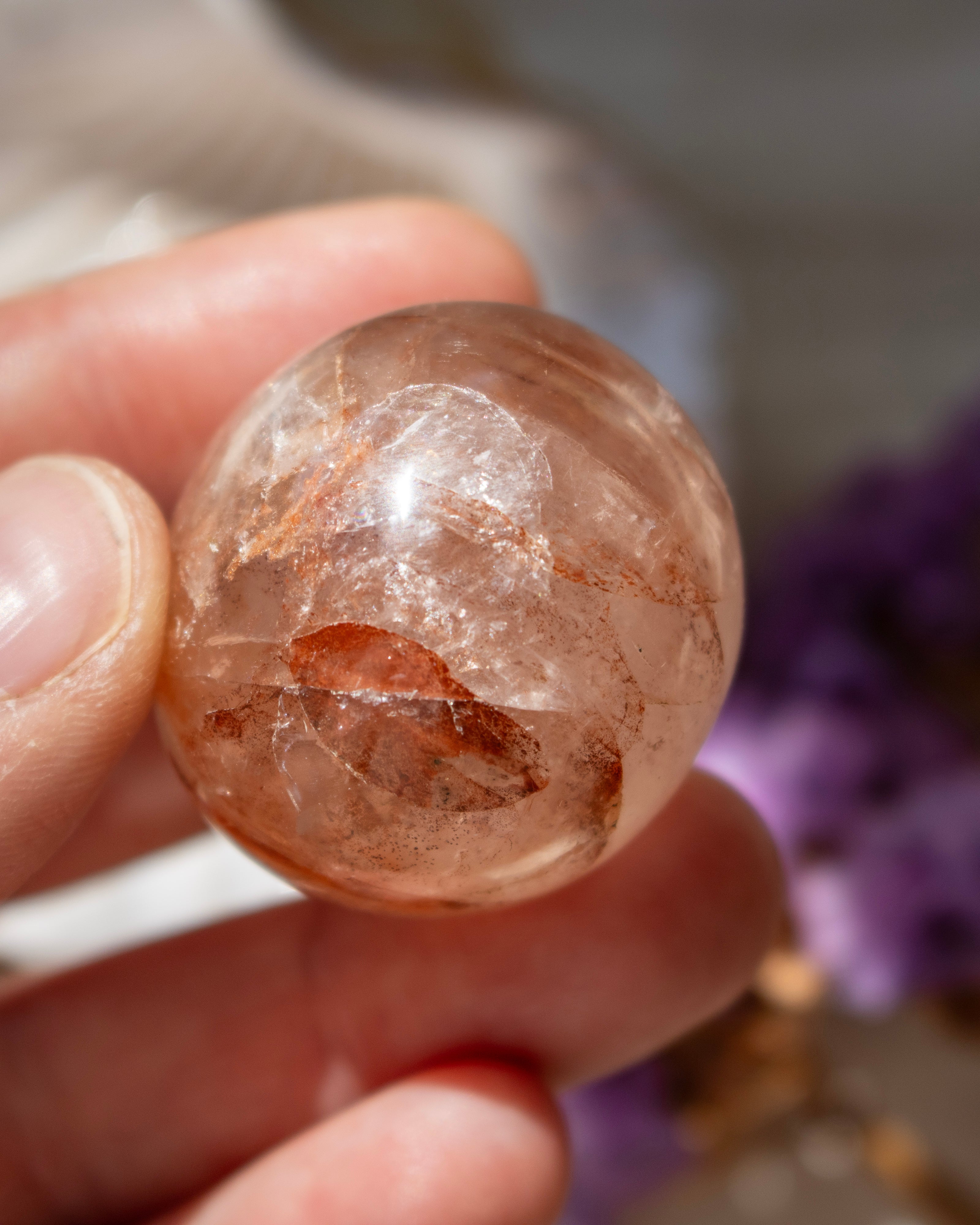 Clear crystal ball held in a hand with a blurred background