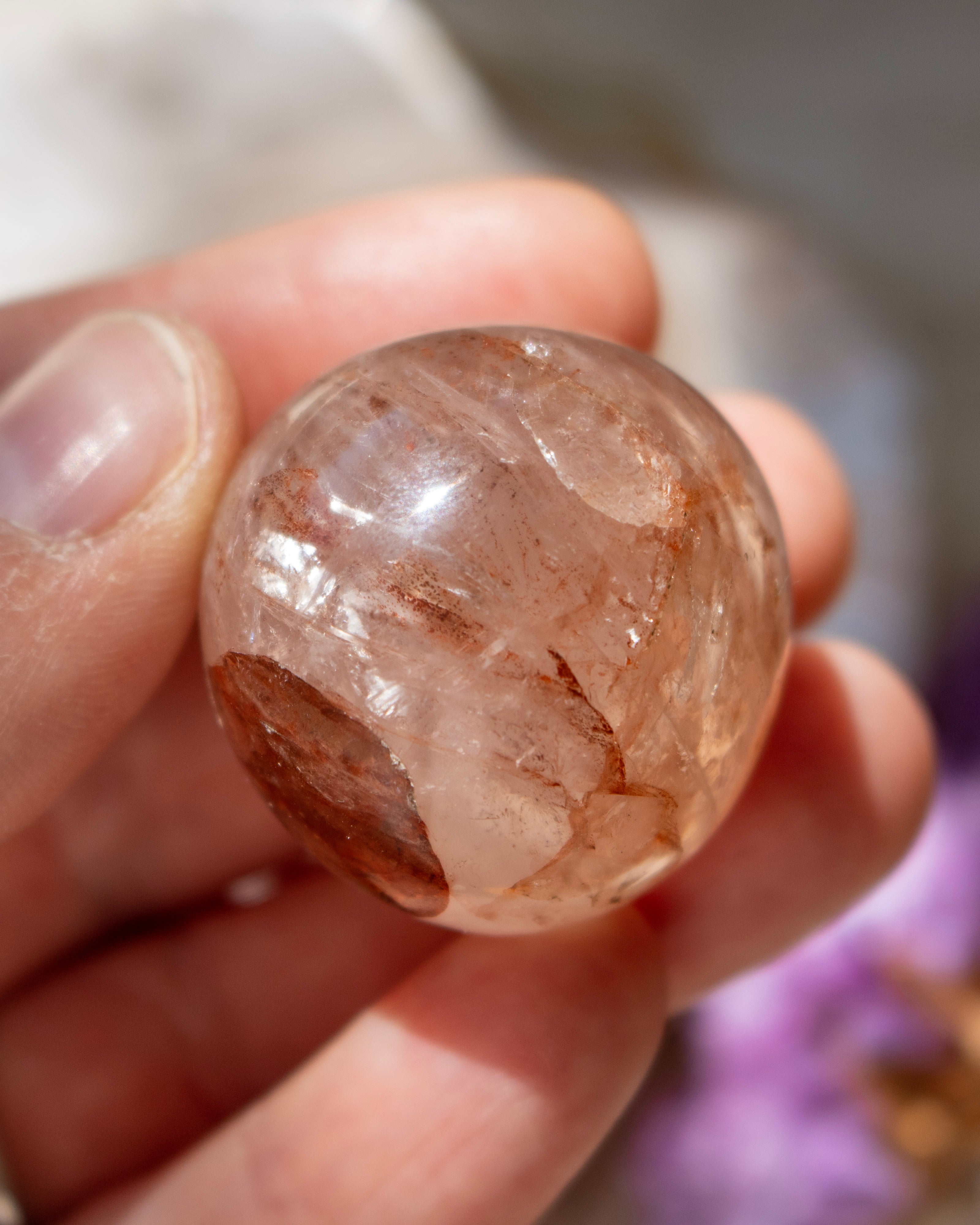 Clear crystal ball held in a hand with a blurred background