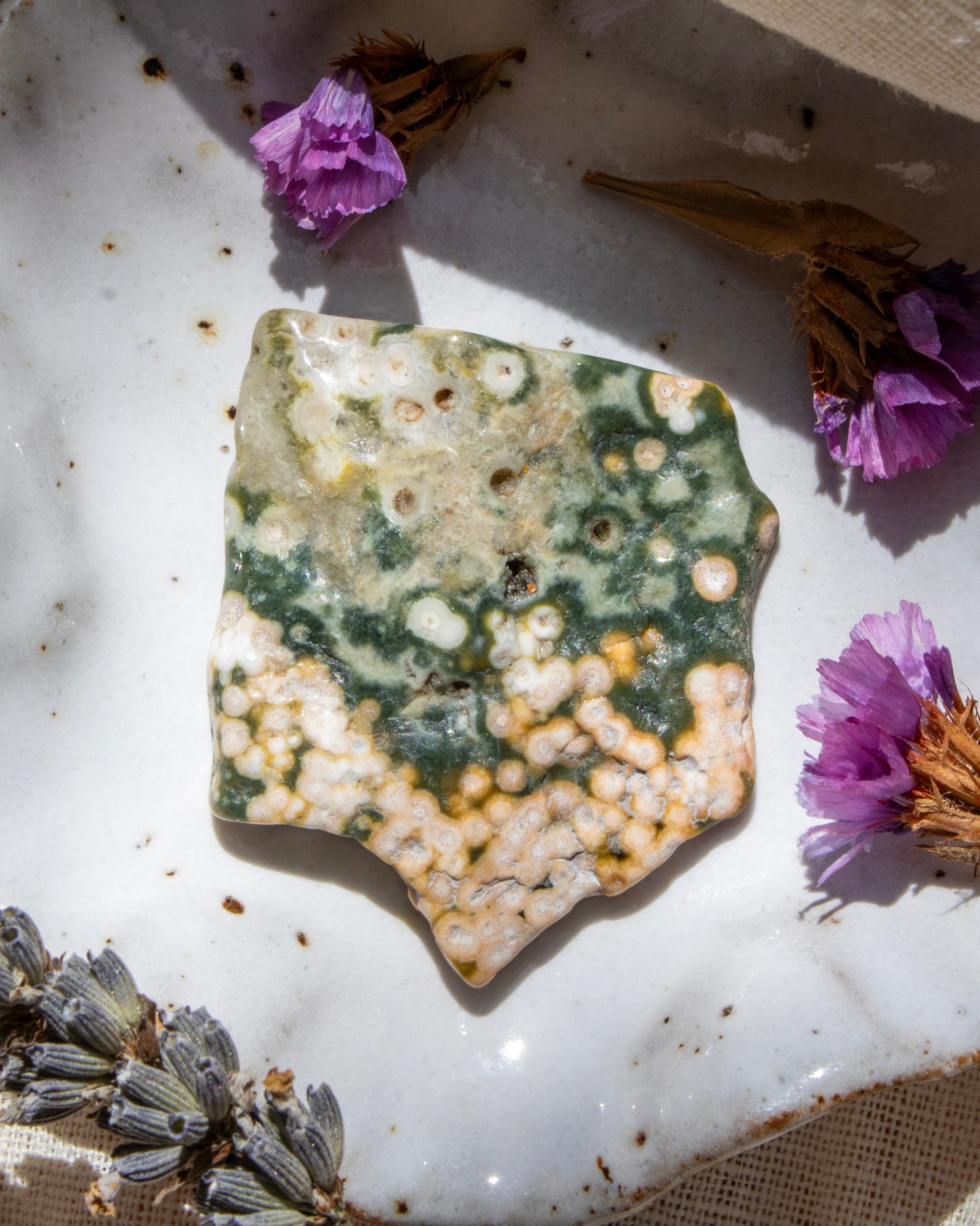 Marble surface with a textured stone and purple flowers
