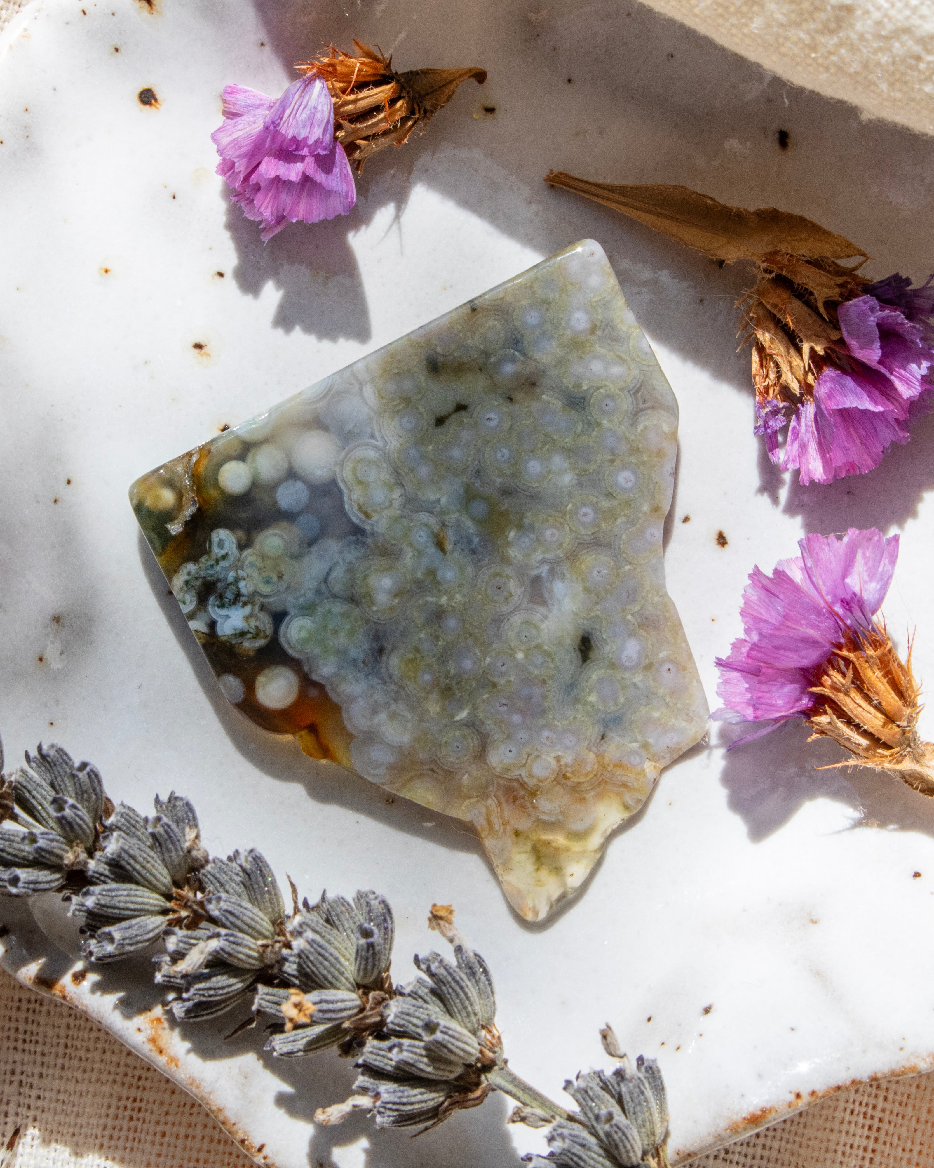 Geode crystal with dried flowers on a textured surface