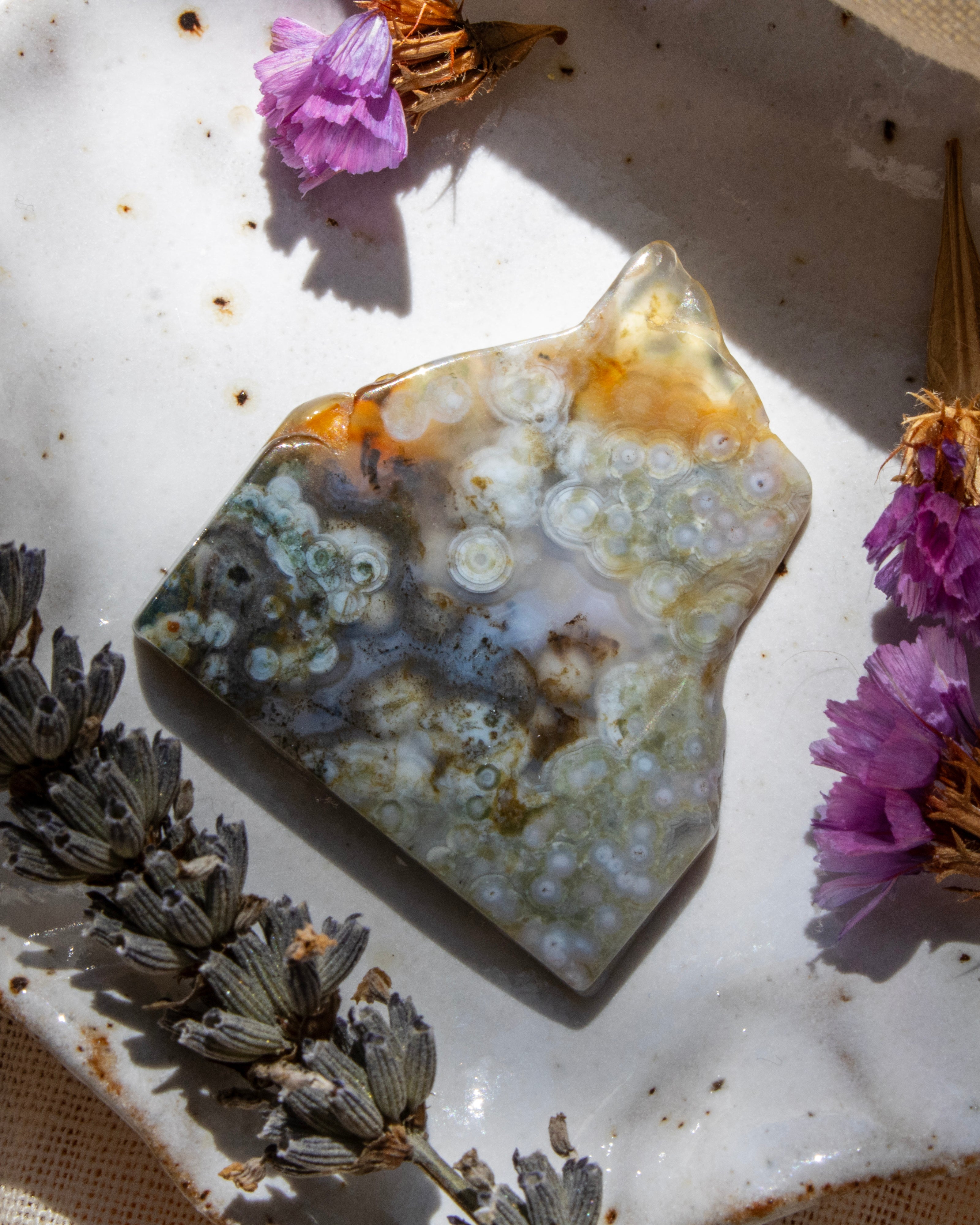 Geode crystal with purple flowers on a textured surface