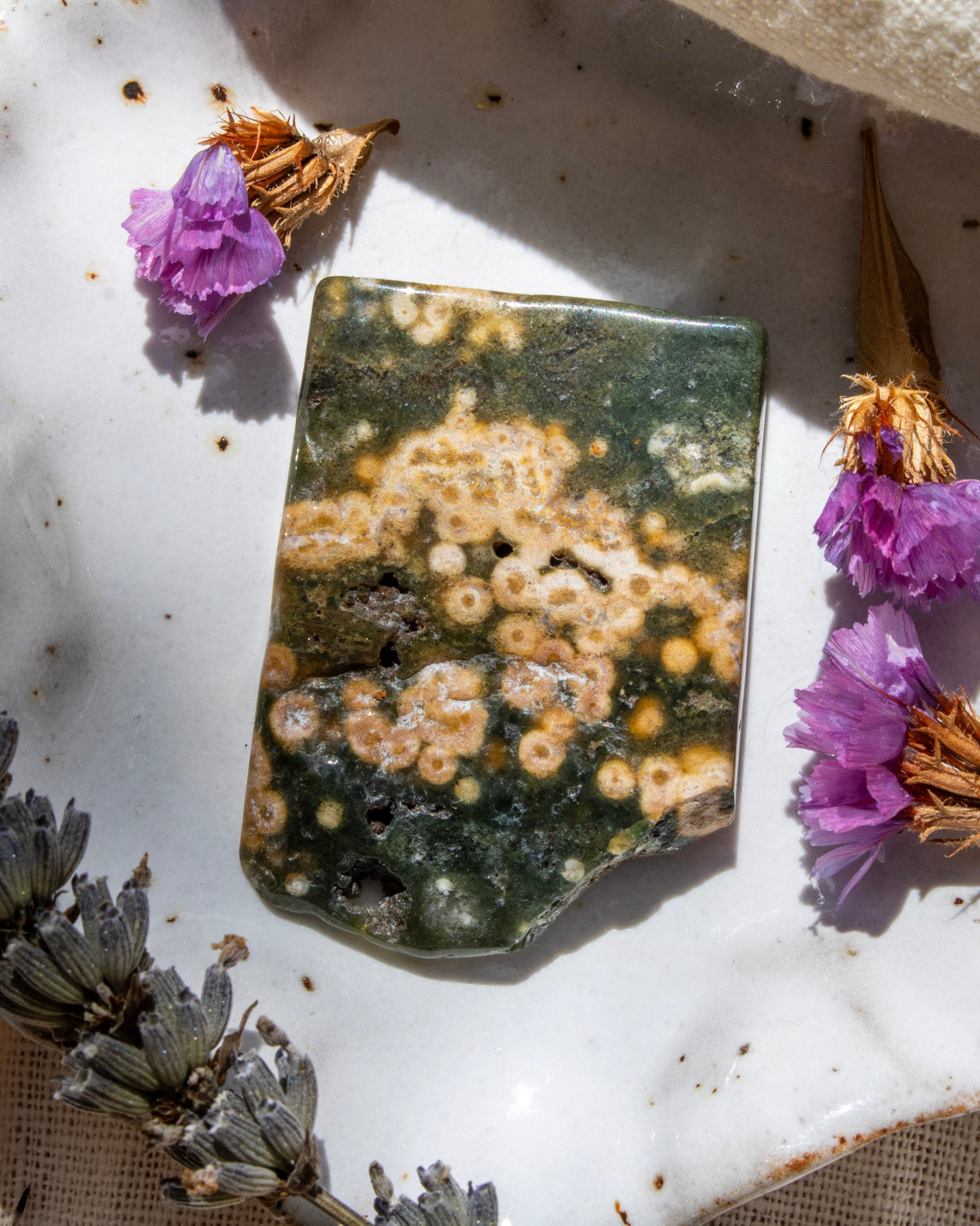 Decorative stone with a floral arrangement on a textured surface