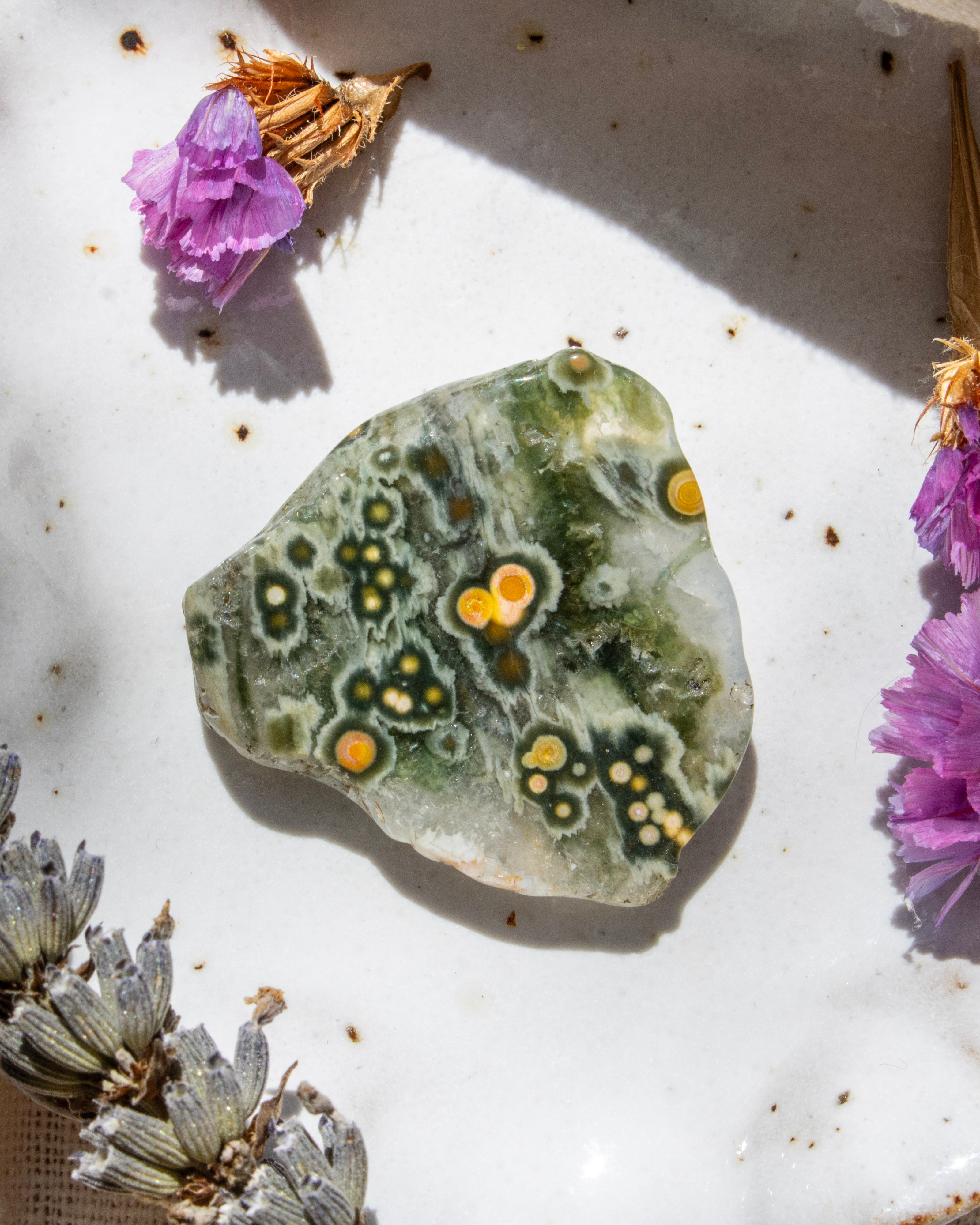 Decorative stone with floral elements on a textured surface