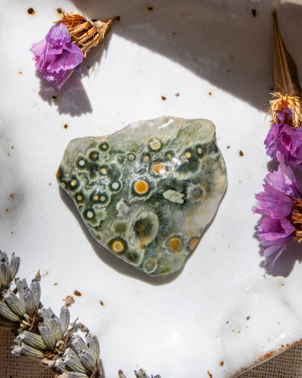 Decorative stone with a floral arrangement on a textured surface