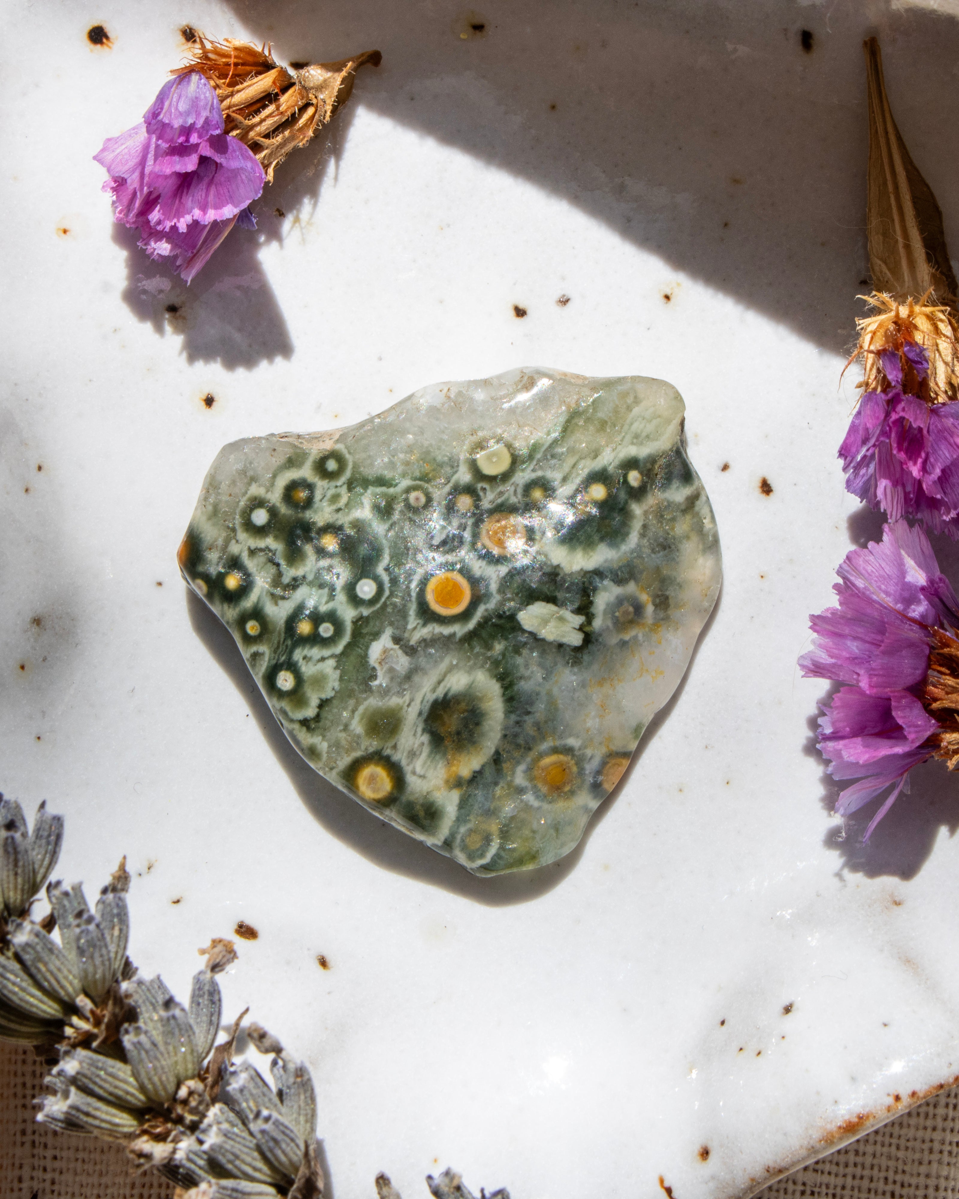 Decorative stone with a floral arrangement on a textured surface