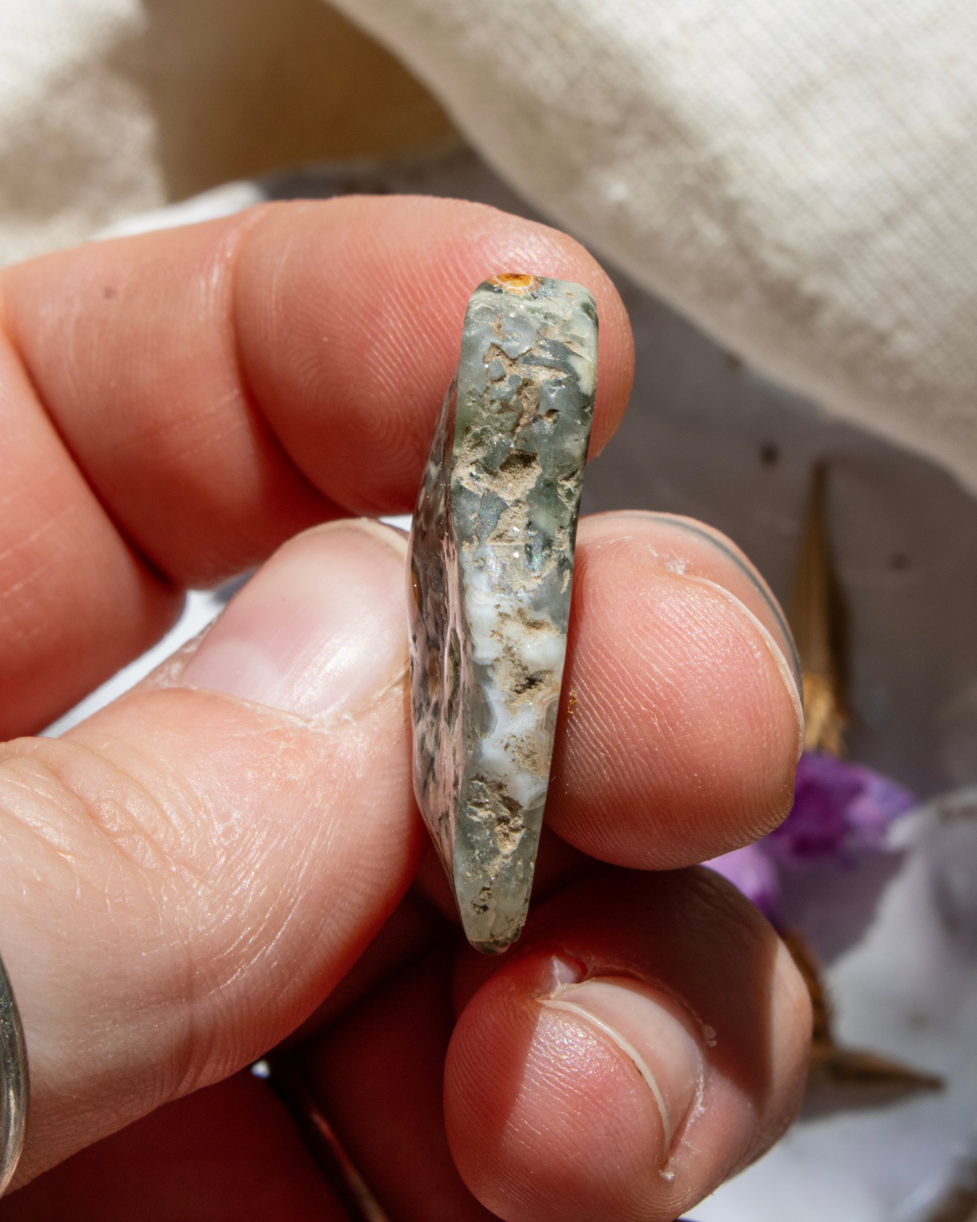 Hand holding a rough stone with a blurred background