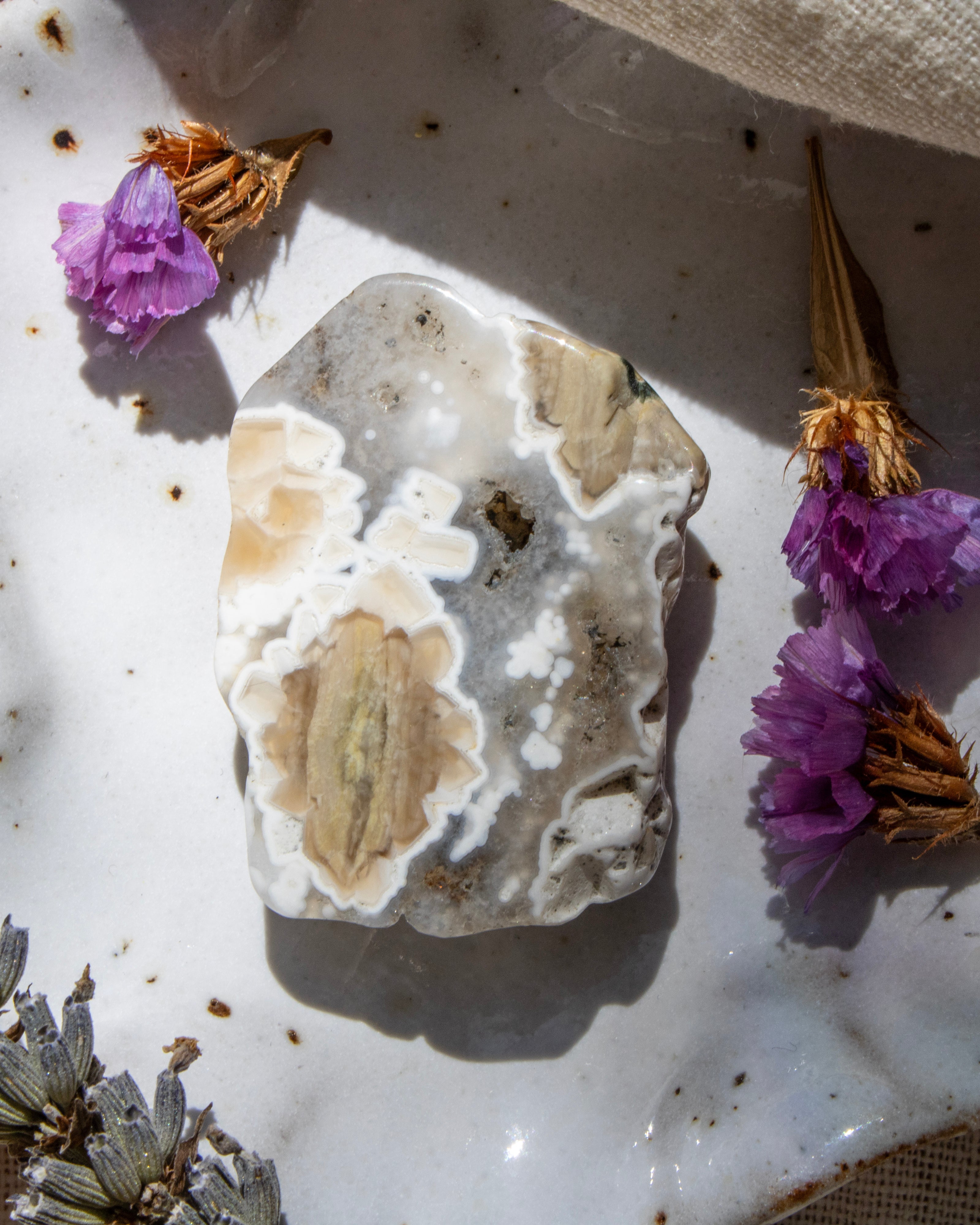 Geode crystal with purple flowers on a textured surface