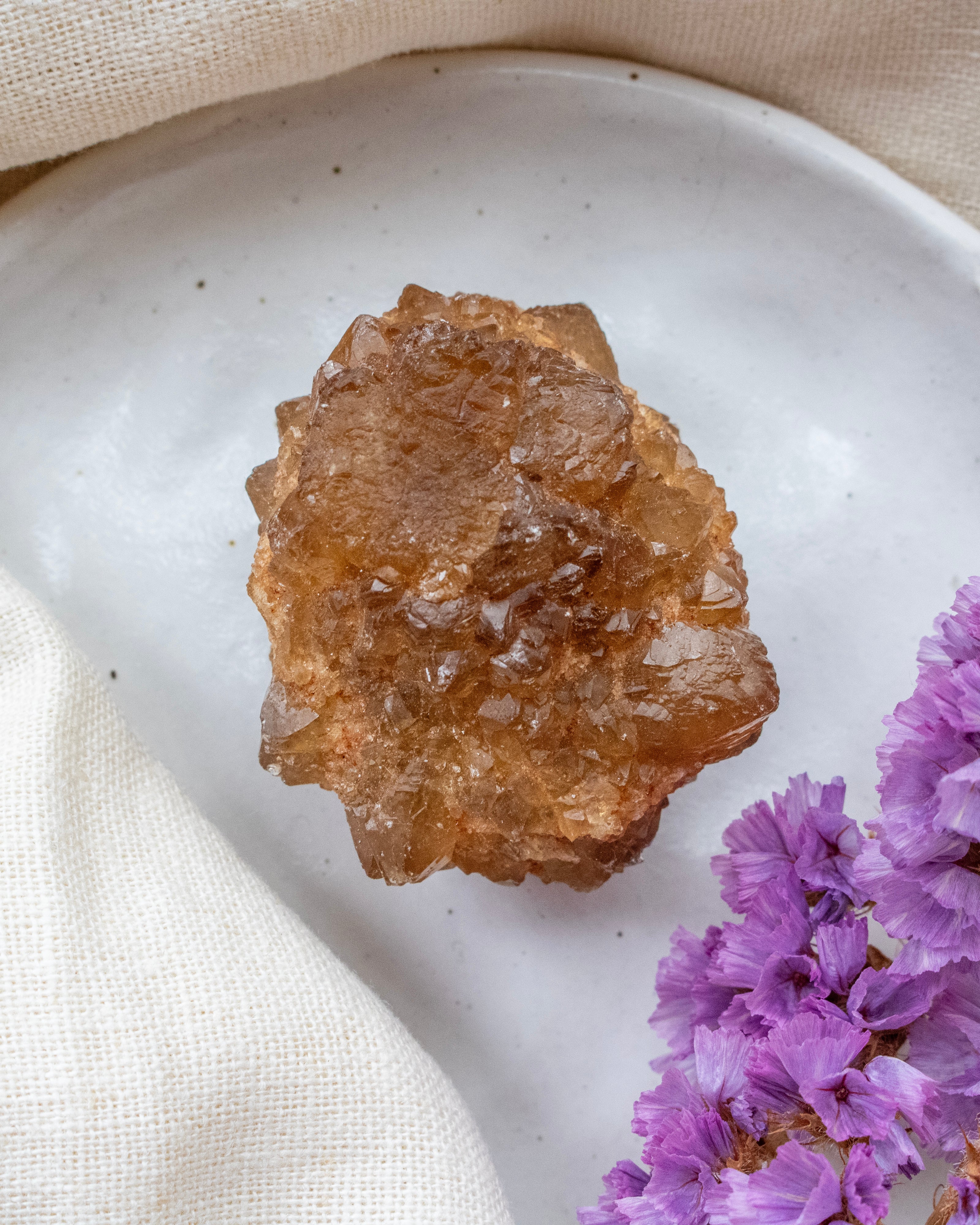 Crystal on a white plate with purple flowers